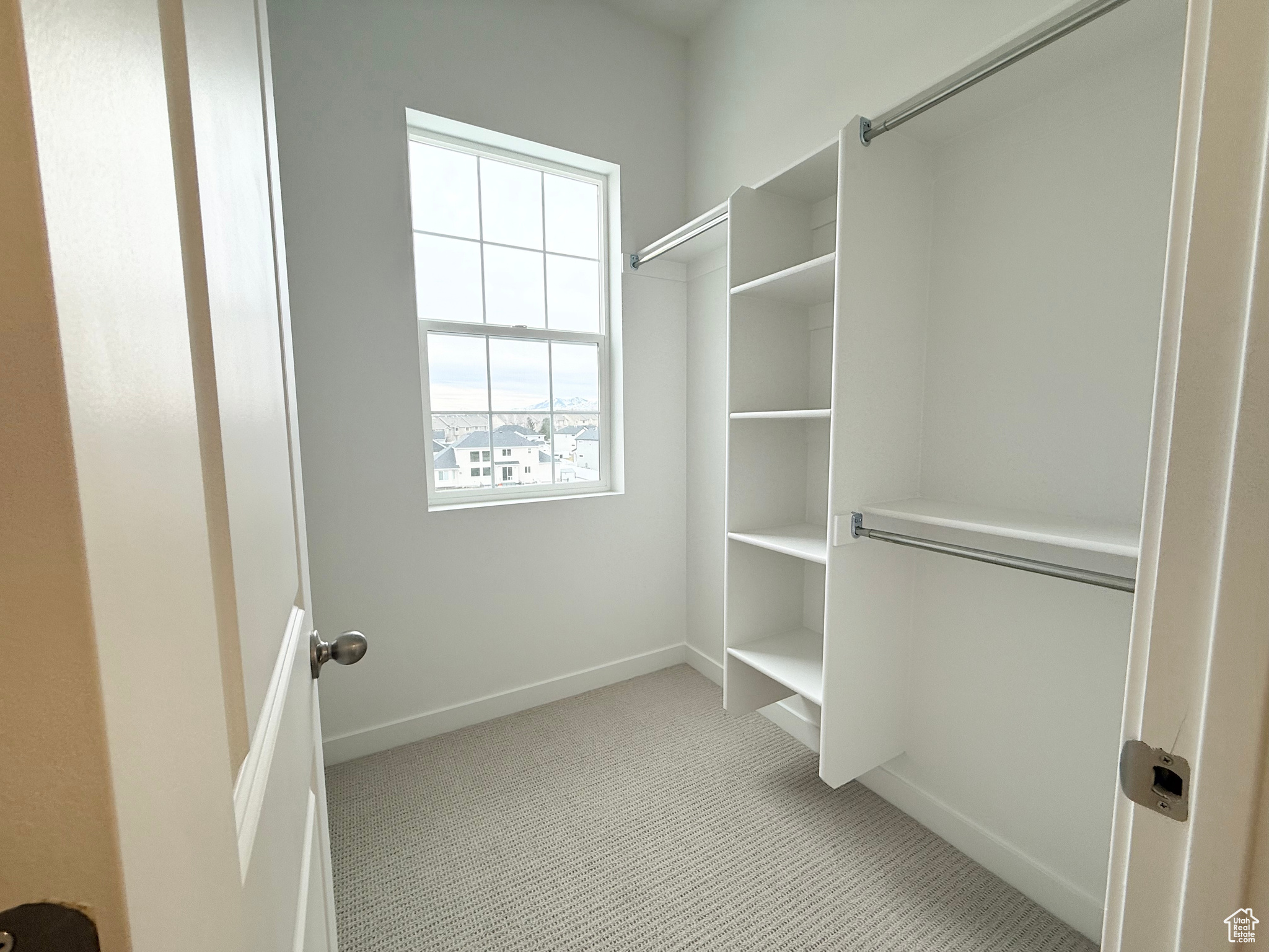 Walk in closet featuring light carpet