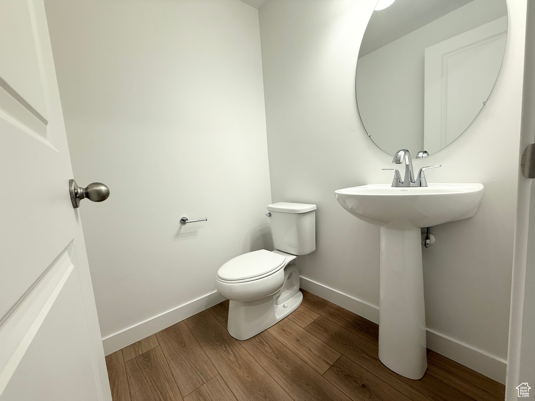 Bathroom with hardwood / wood-style flooring, toilet, and sink