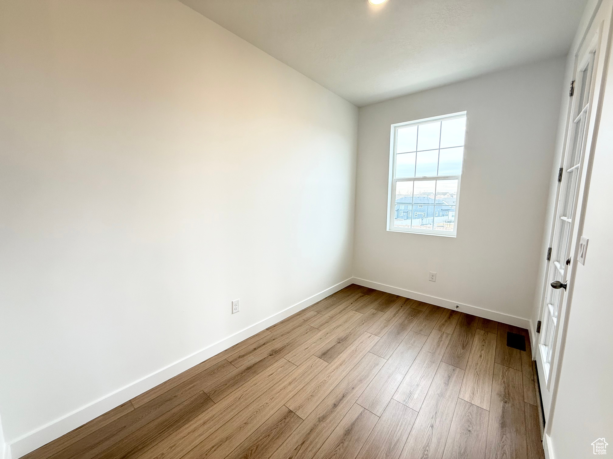 Empty room with light hardwood / wood-style floors