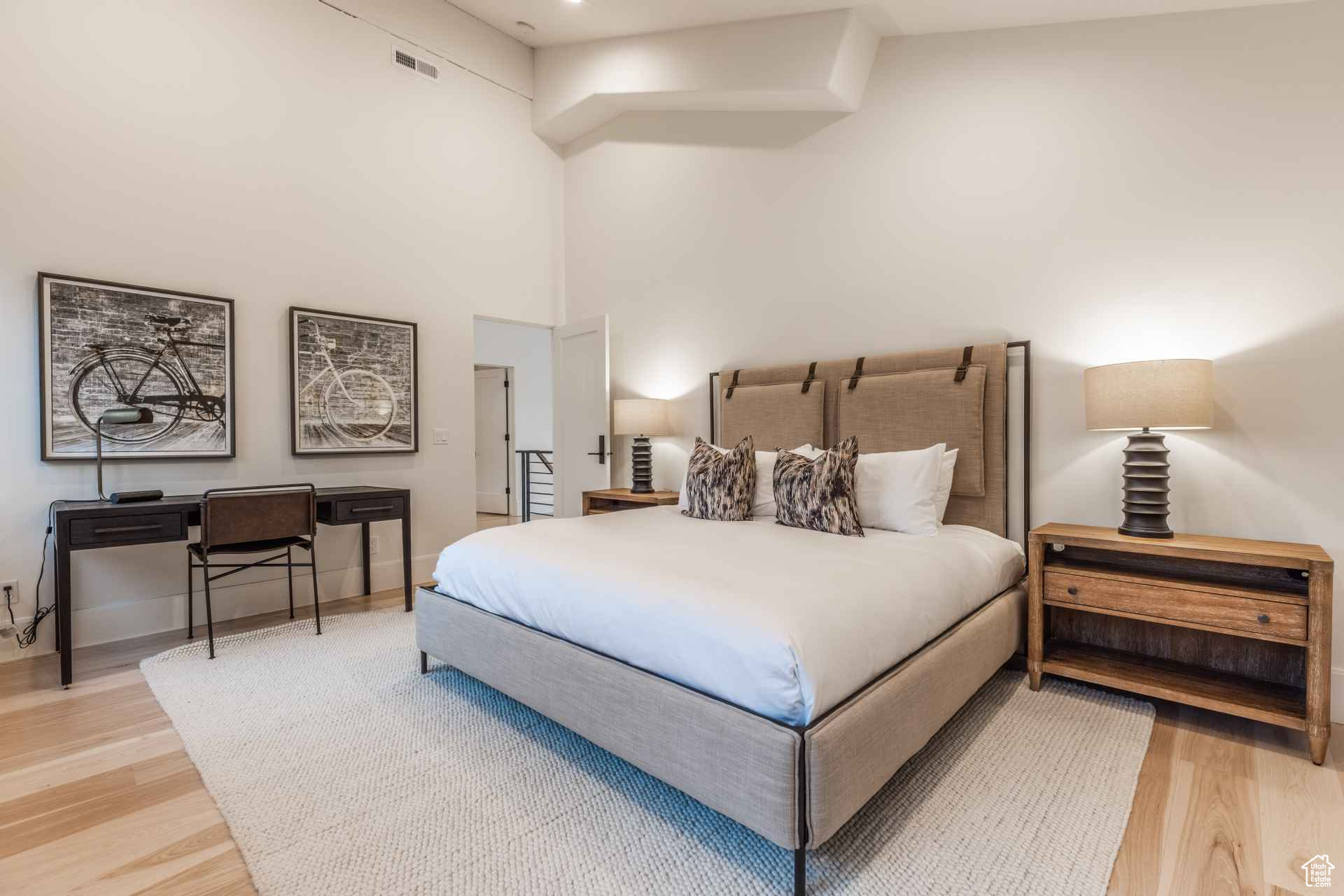 Bedroom with a towering ceiling and light hardwood / wood-style flooring