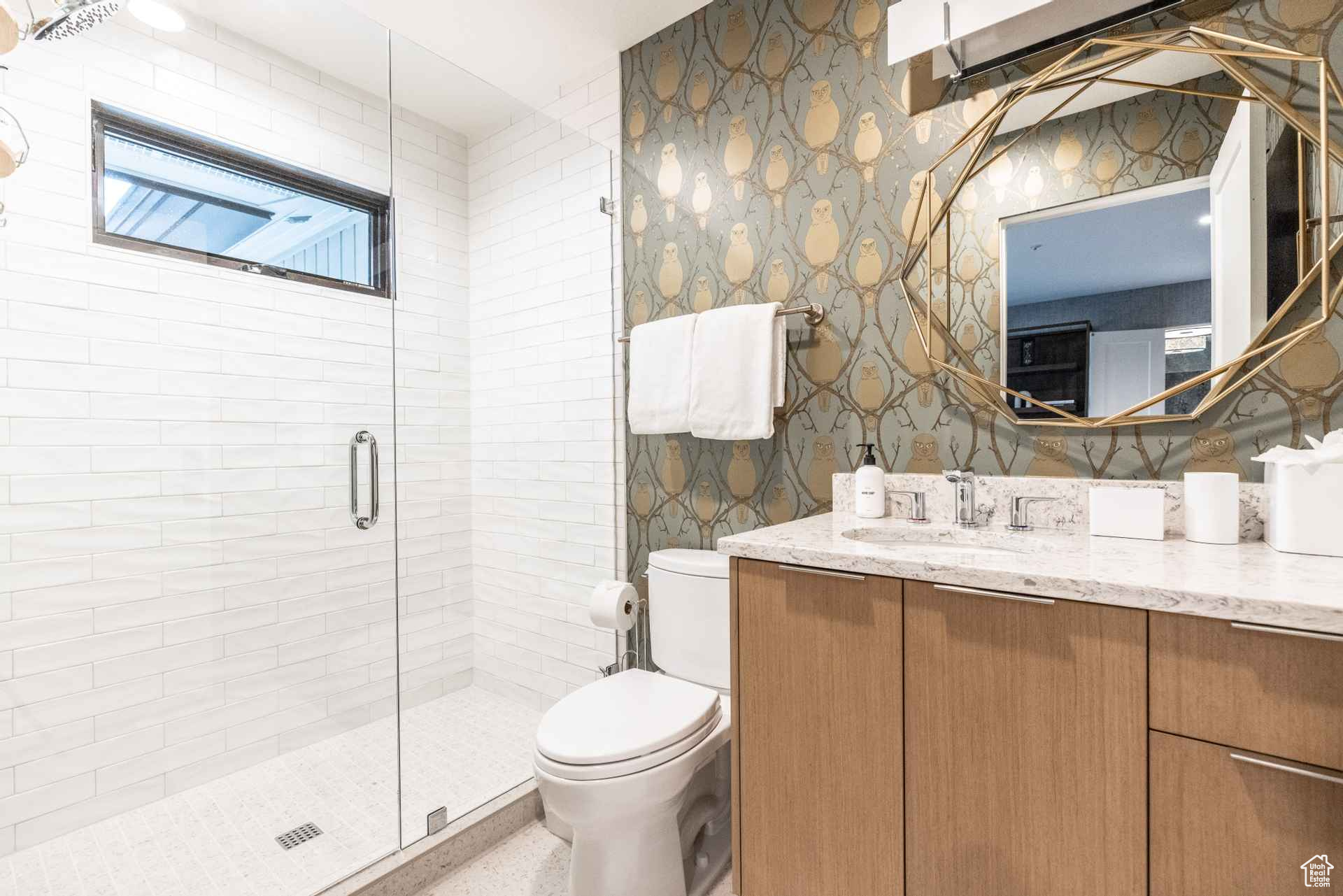 Bathroom featuring vanity, toilet, and an enclosed shower