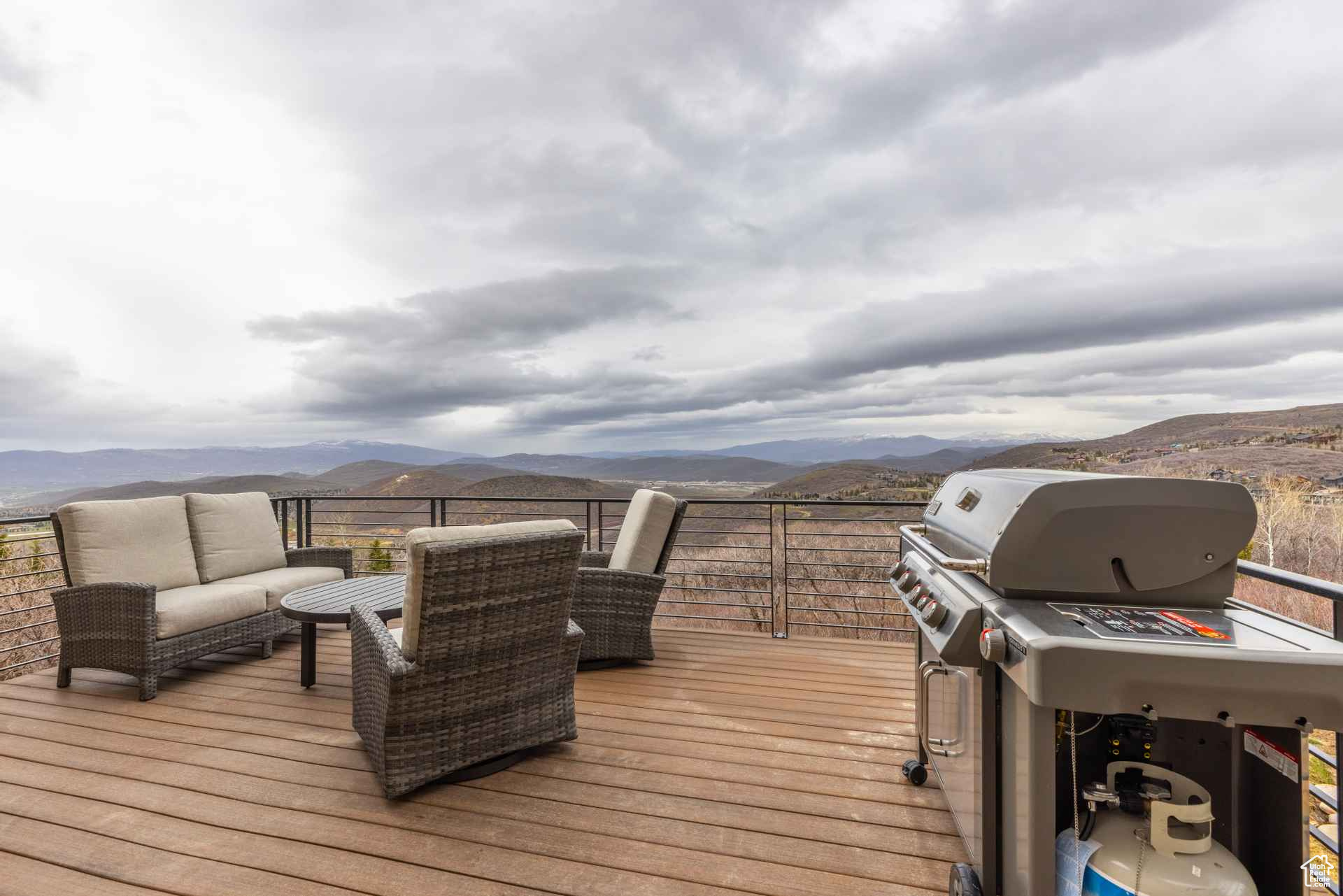 Wooden terrace featuring a grill, a mountain view, and an outdoor living space