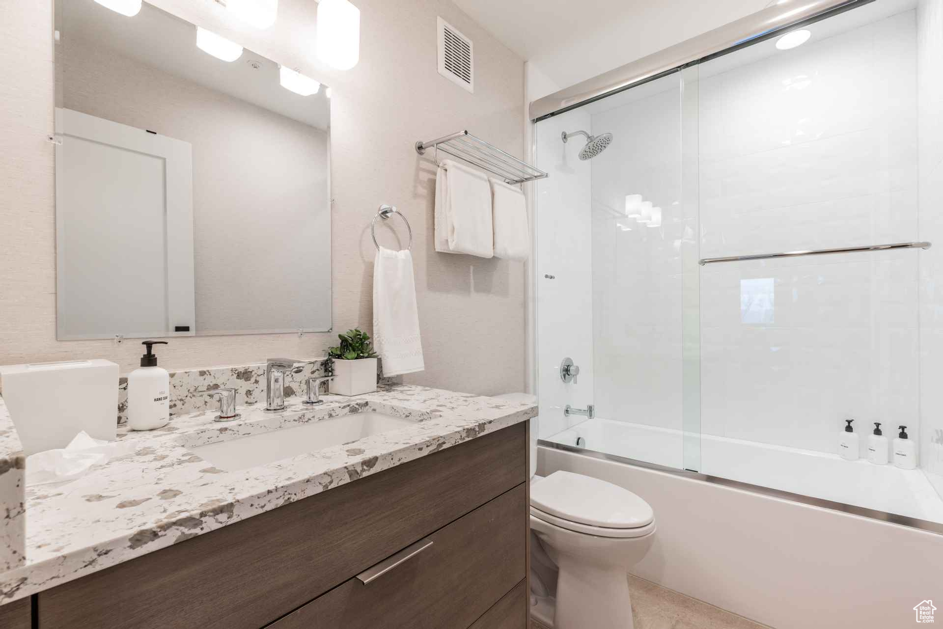 Full bathroom with vanity, toilet, and combined bath / shower with glass door