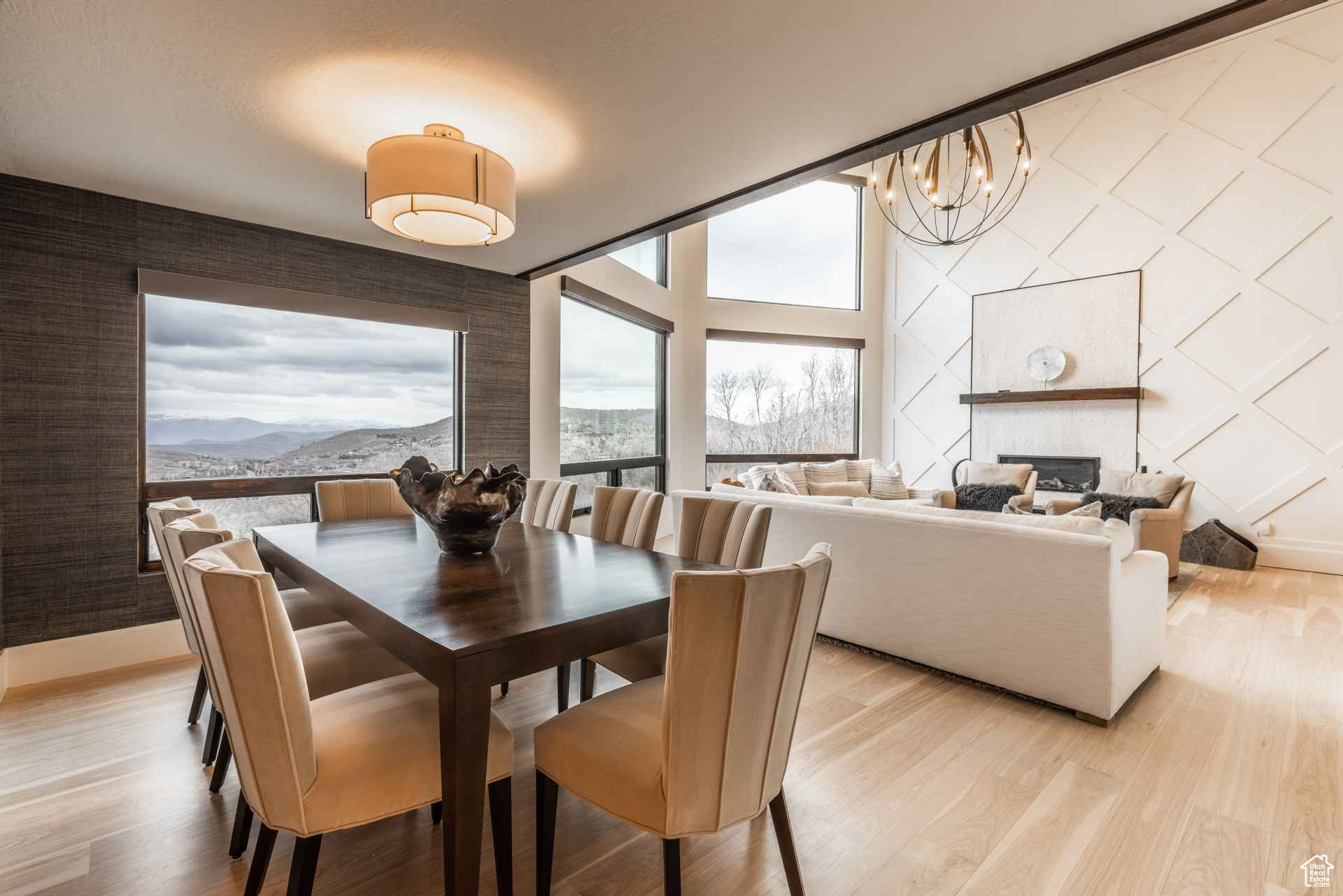 Dining area featuring a mountain view, an inviting chandelier, a fireplace, and light wood-type flooring