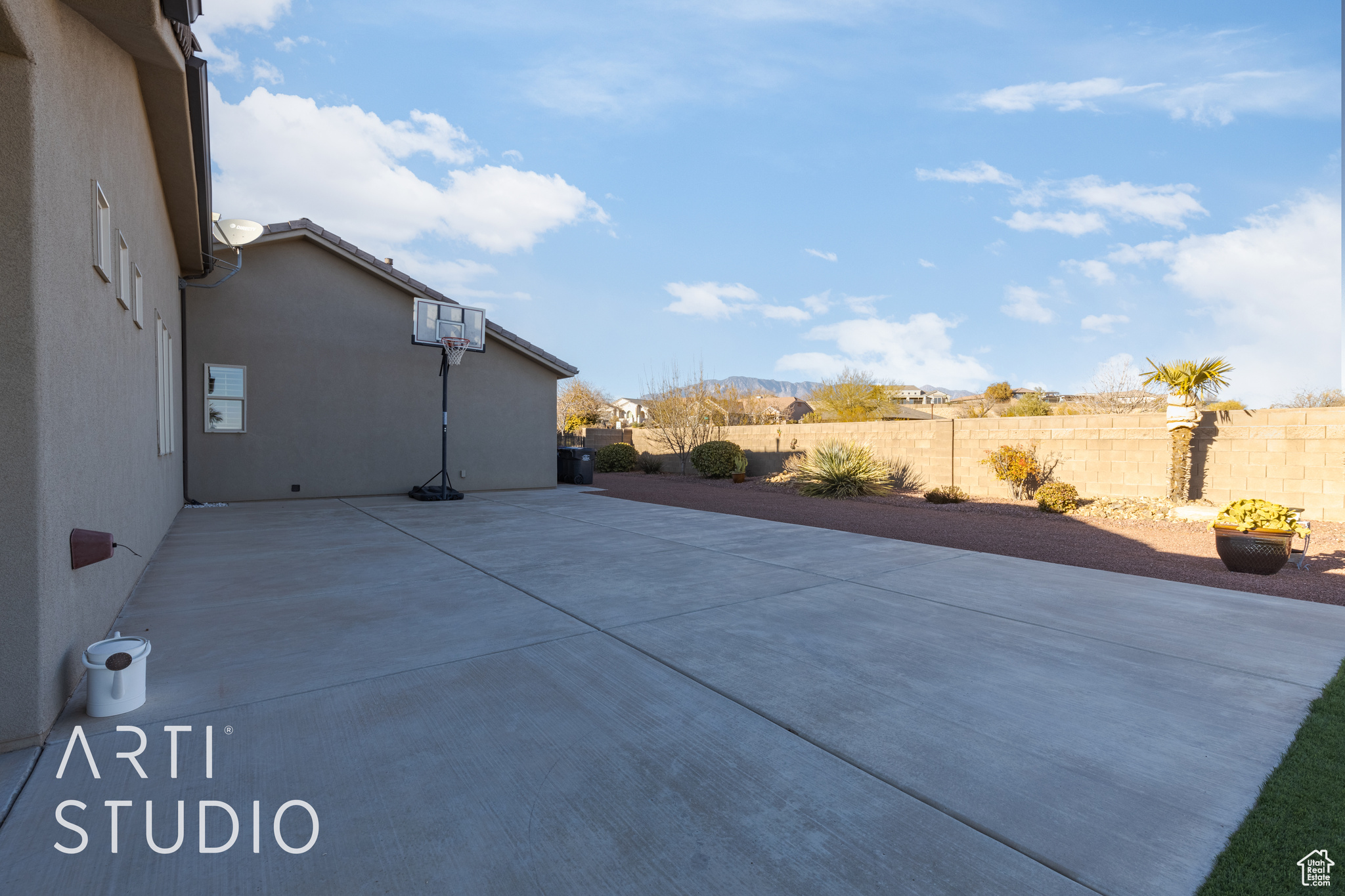 Side yard with basketball hoop behind garage