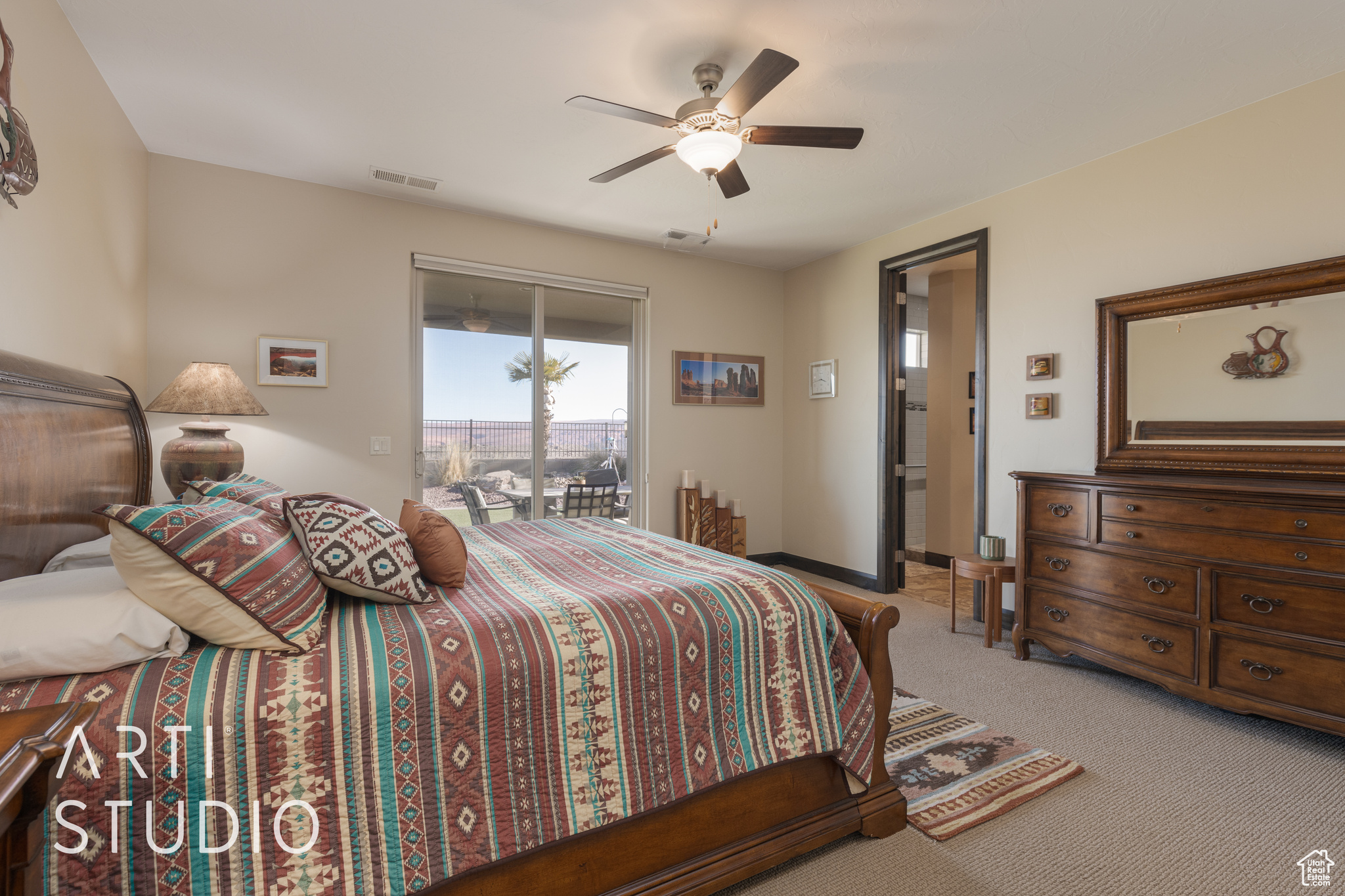 Master bedroom featuring access to outside, light colored carpet, and ceiling fan