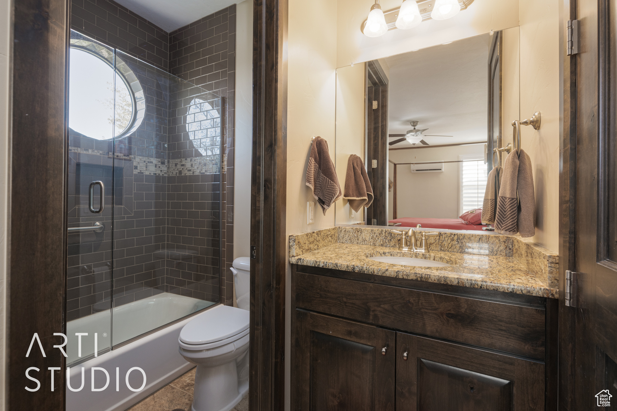 Full casita bathroom featuring ceiling fan, enclosed tub / shower combo, vanity, and toilet