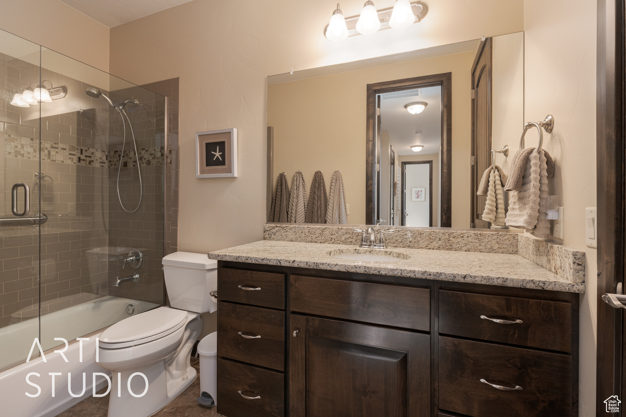 Full bathroom for bedroom 3,  featuring shower / bath combination with glass door, vanity, and toilet