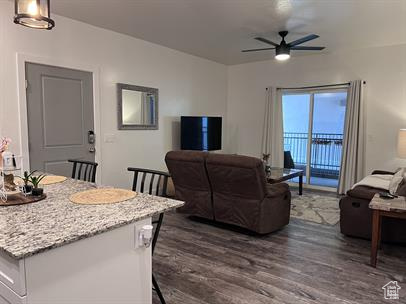 Living room with dark wood-type flooring and ceiling fan