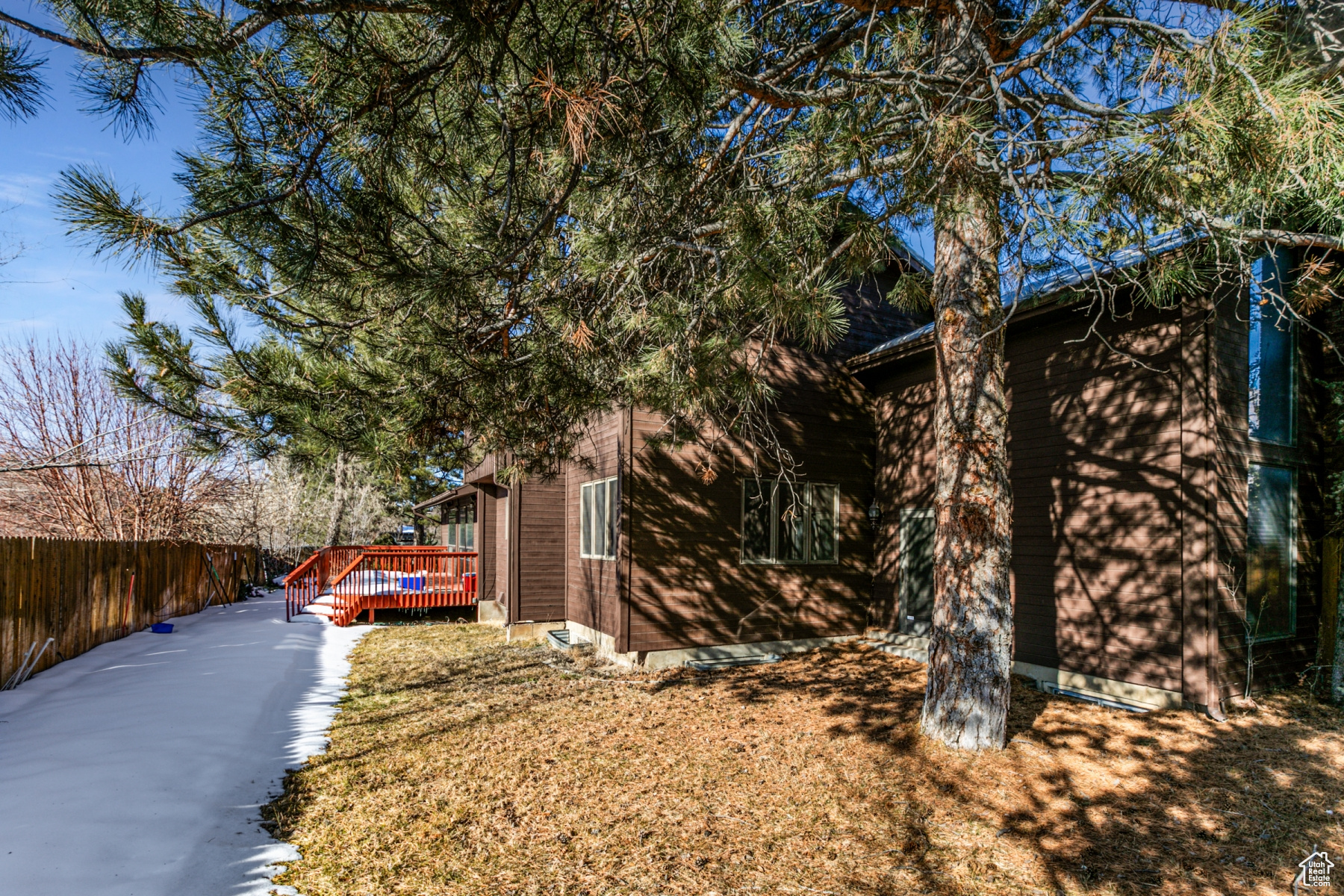 View of side of home with a wooden deck and a yard