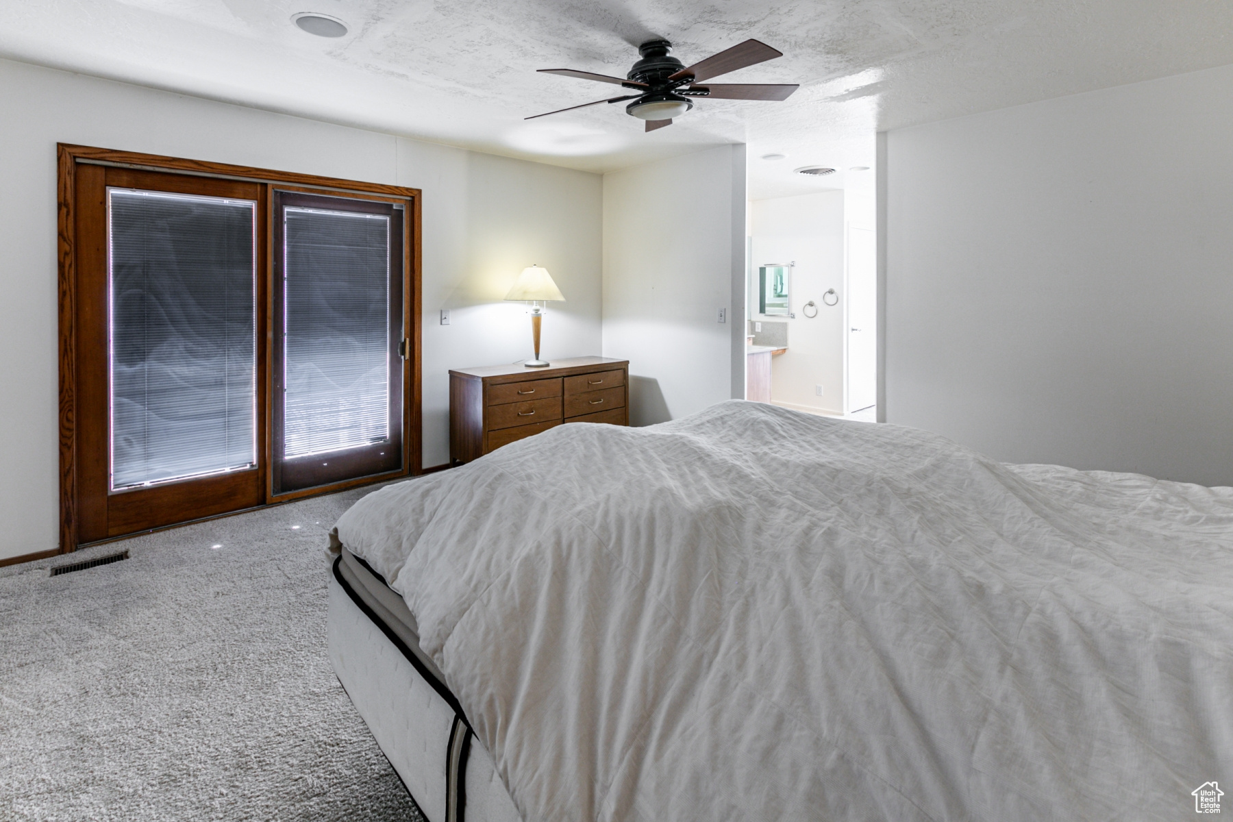 Carpeted bedroom featuring ceiling fan, connected bathroom, access to outside, and a textured ceiling