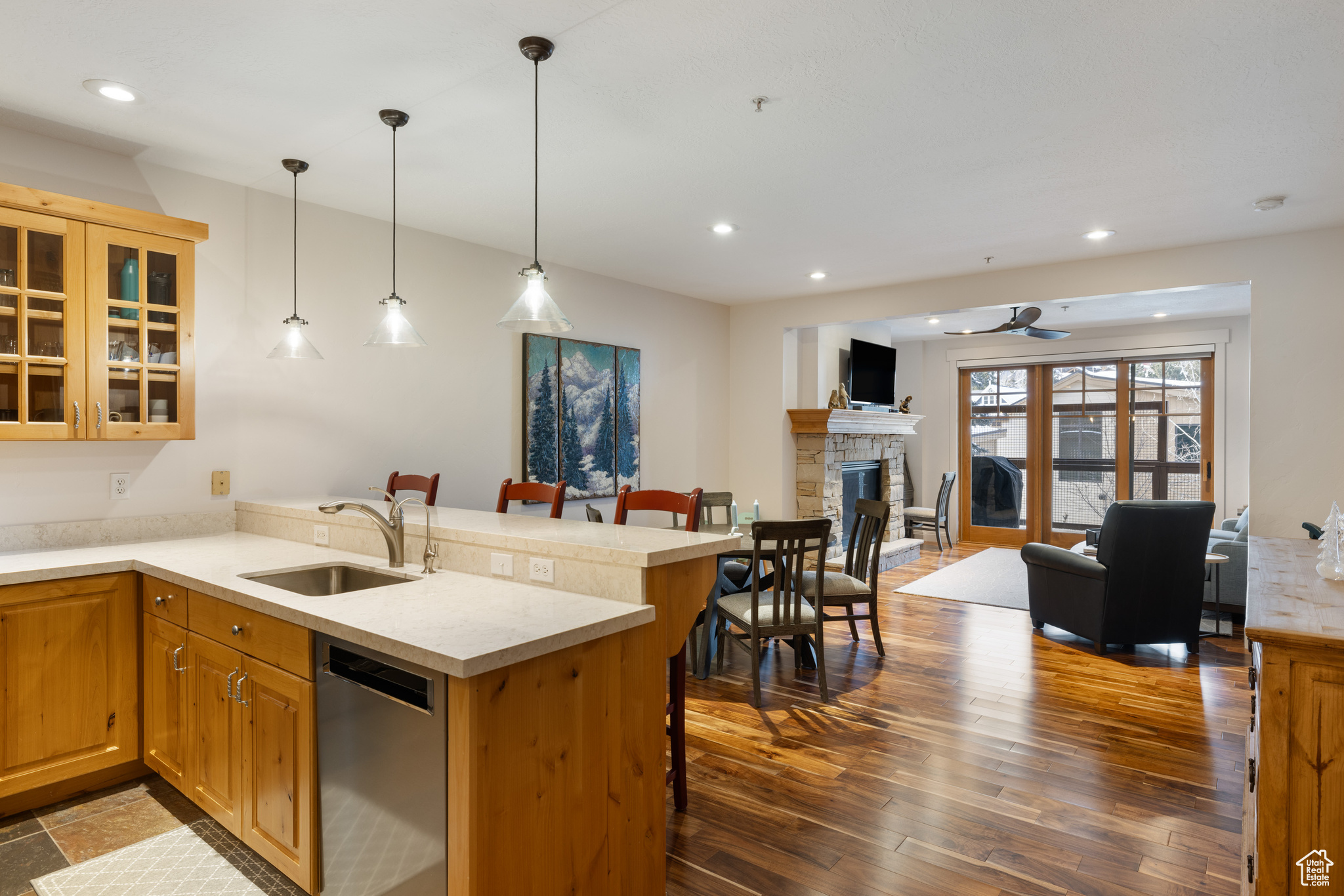 Kitchen featuring sink, a kitchen breakfast bar, dishwashing machine, kitchen peninsula, and pendant lighting