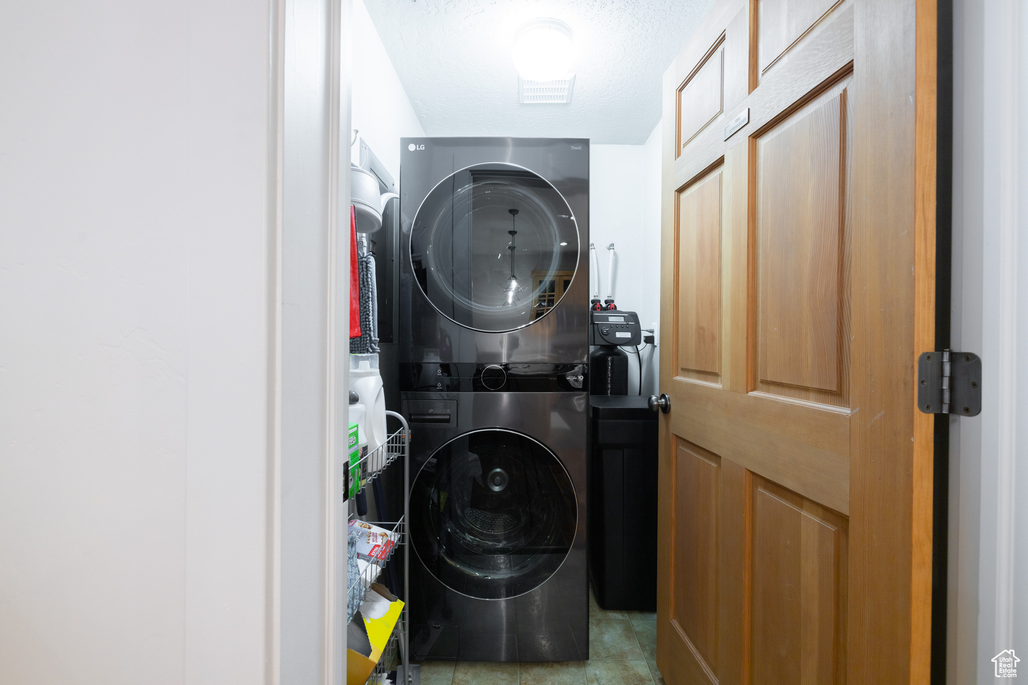 Washroom featuring stacked washer and clothes dryer