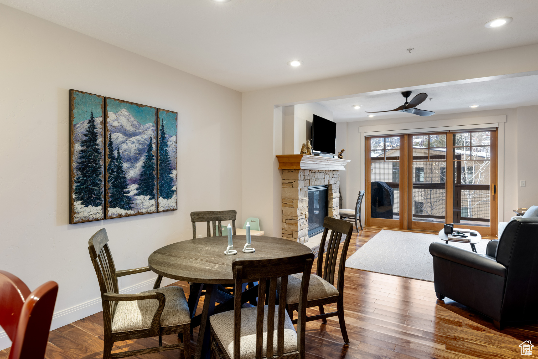 Dining room featuring ceiling fan, hardwood / wood-style floors, and a fireplace