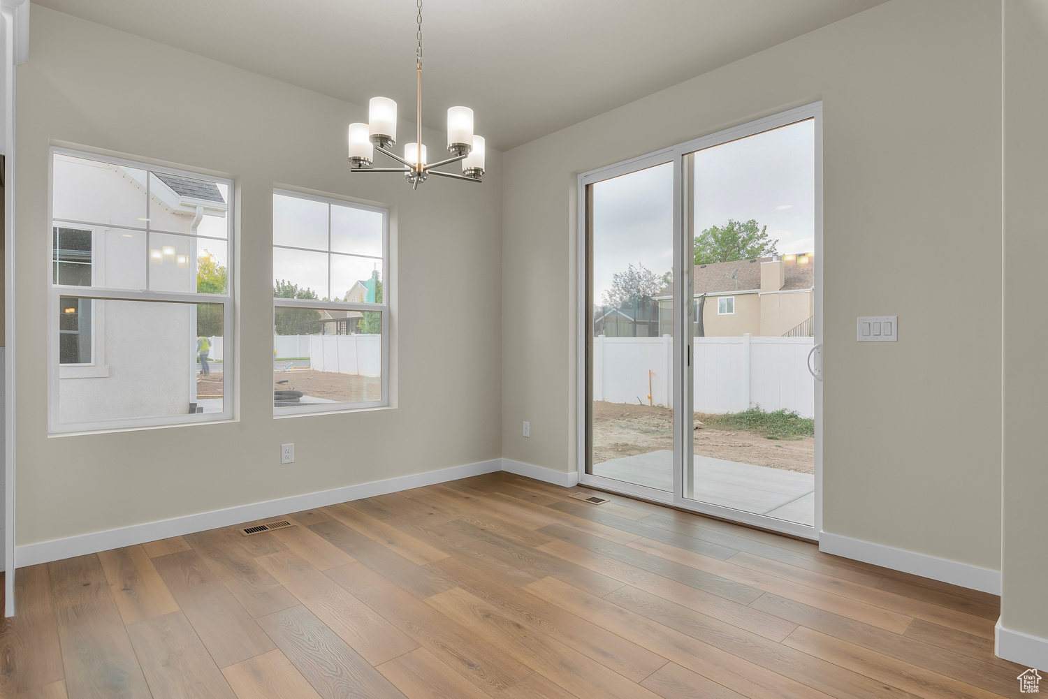 Unfurnished dining area with hardwood / wood-style floors and a chandelier