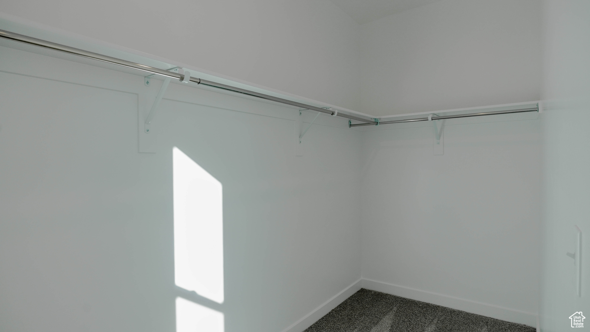Spacious closet with dark carpet