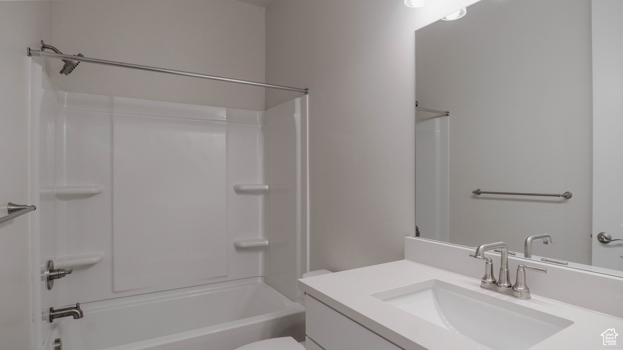 Bathroom with toilet, vanity, and  shower combination