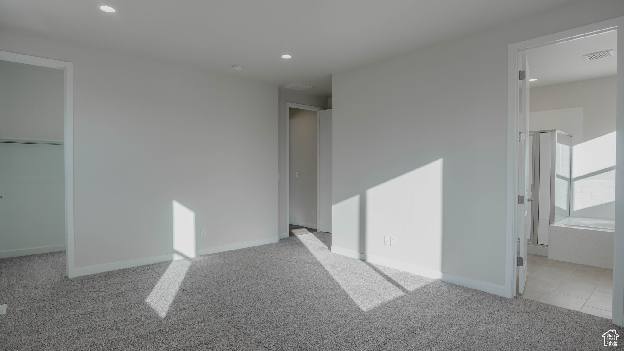 Unfurnished bedroom featuring carpet flooring, recessed lighting, ensuite bath, and baseboards