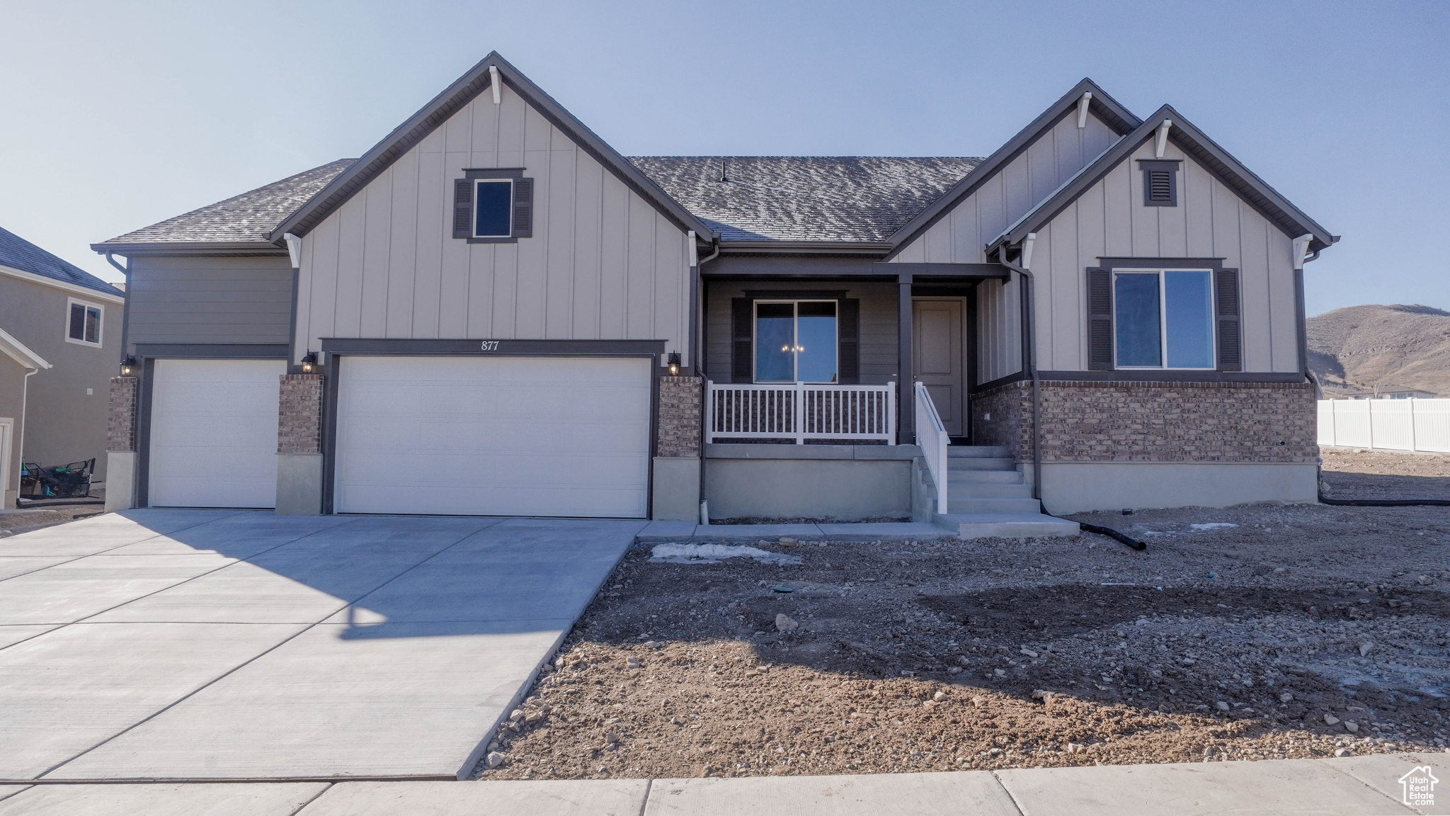 Modern inspired farmhouse featuring a garage, board and batten siding, a porch, and driveway