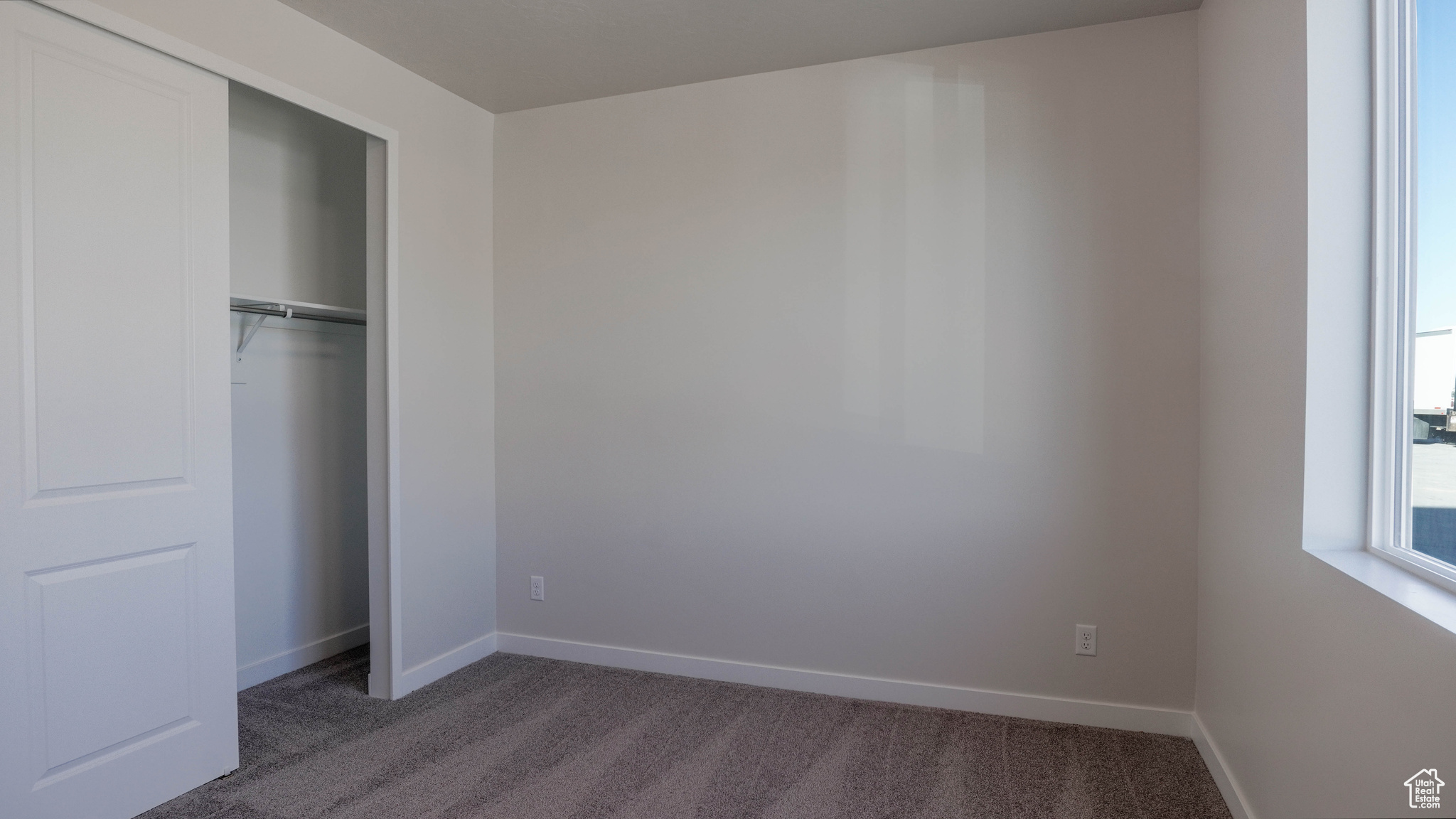 Unfurnished bedroom with a closet, baseboards, and carpet flooring