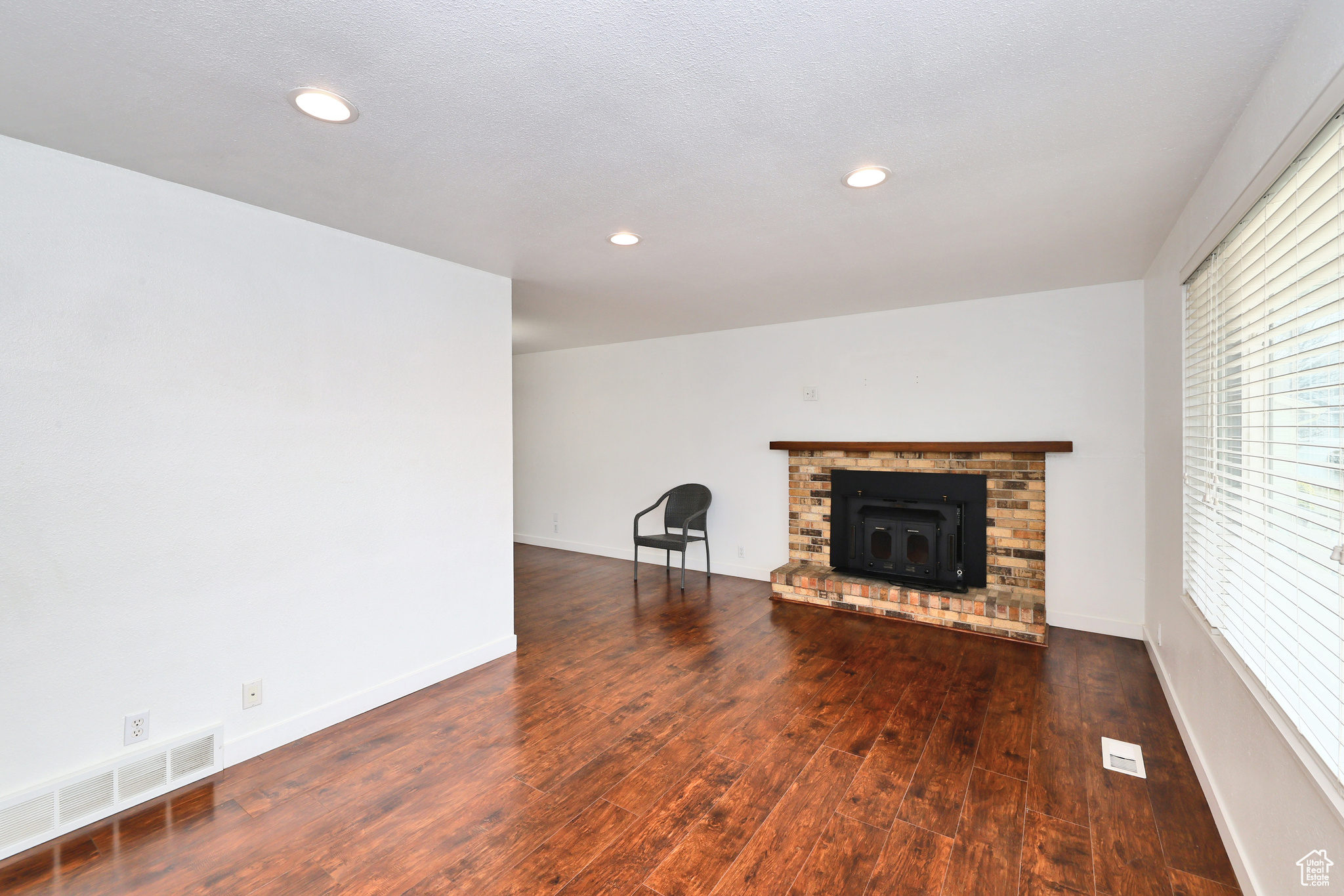 Unfurnished living room featuring dark wood-type flooring