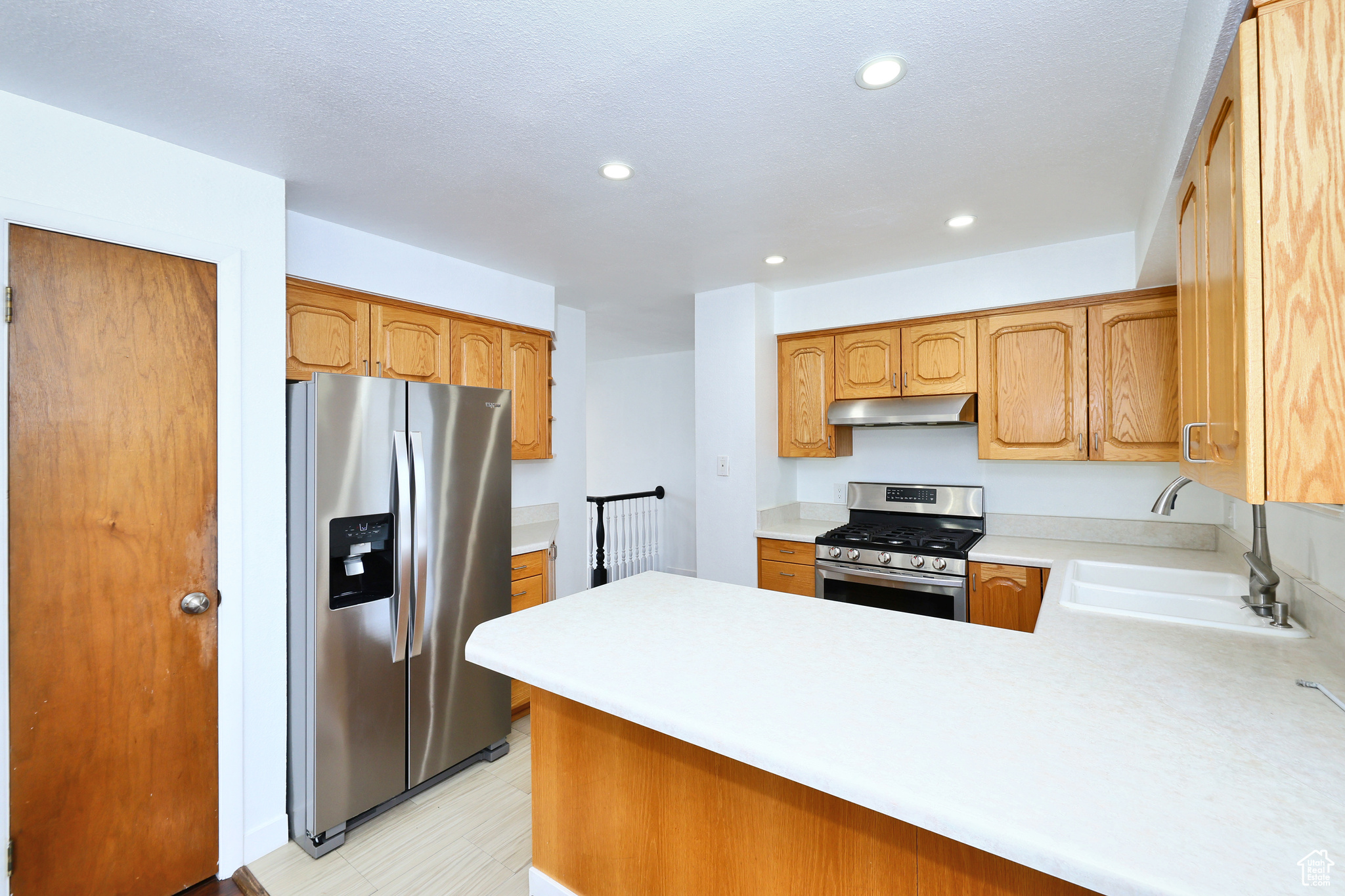 Kitchen featuring stainless steel appliances, kitchen peninsula, and sink