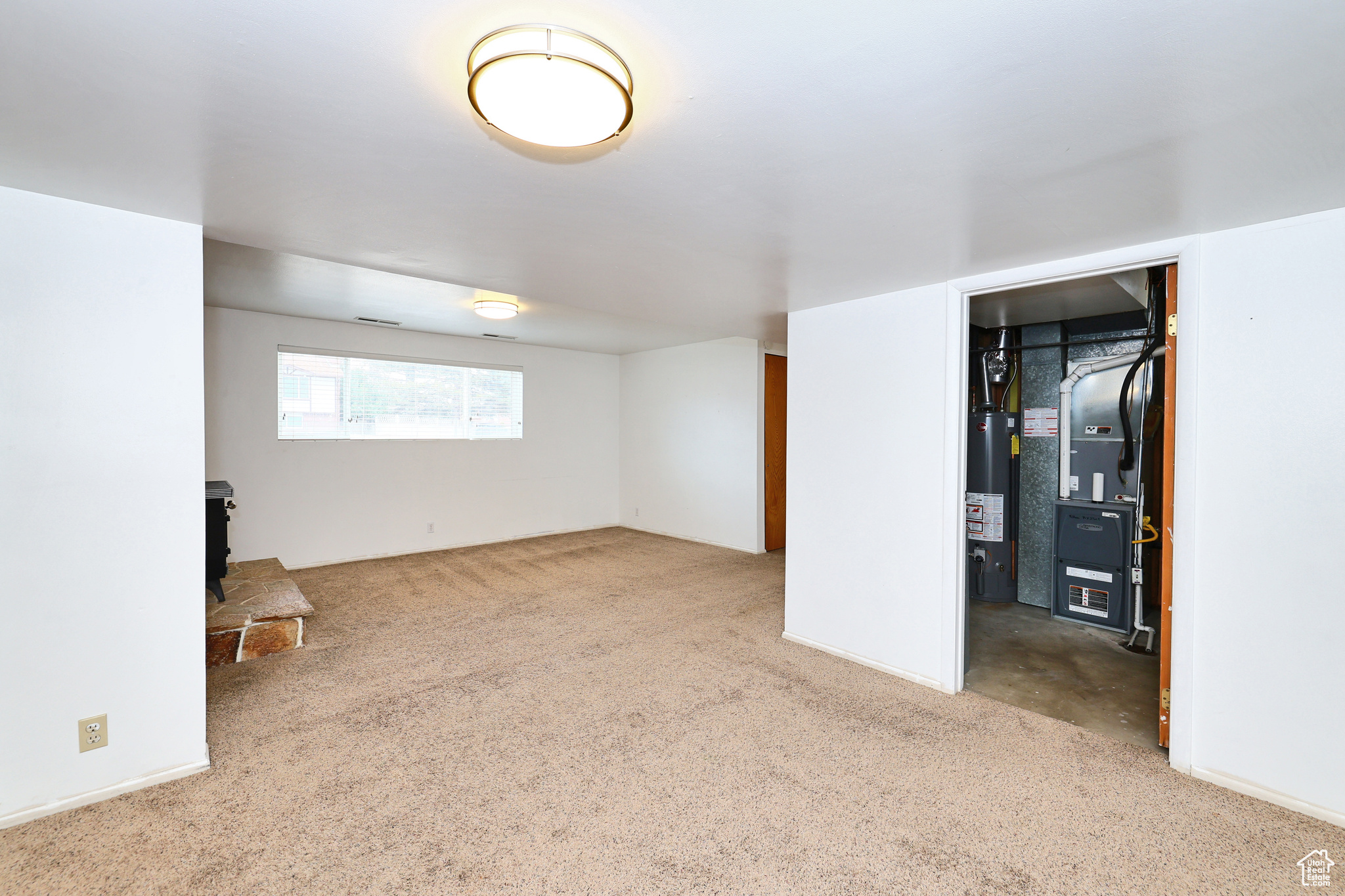 Basement featuring heating unit, carpet floors, and gas water heater