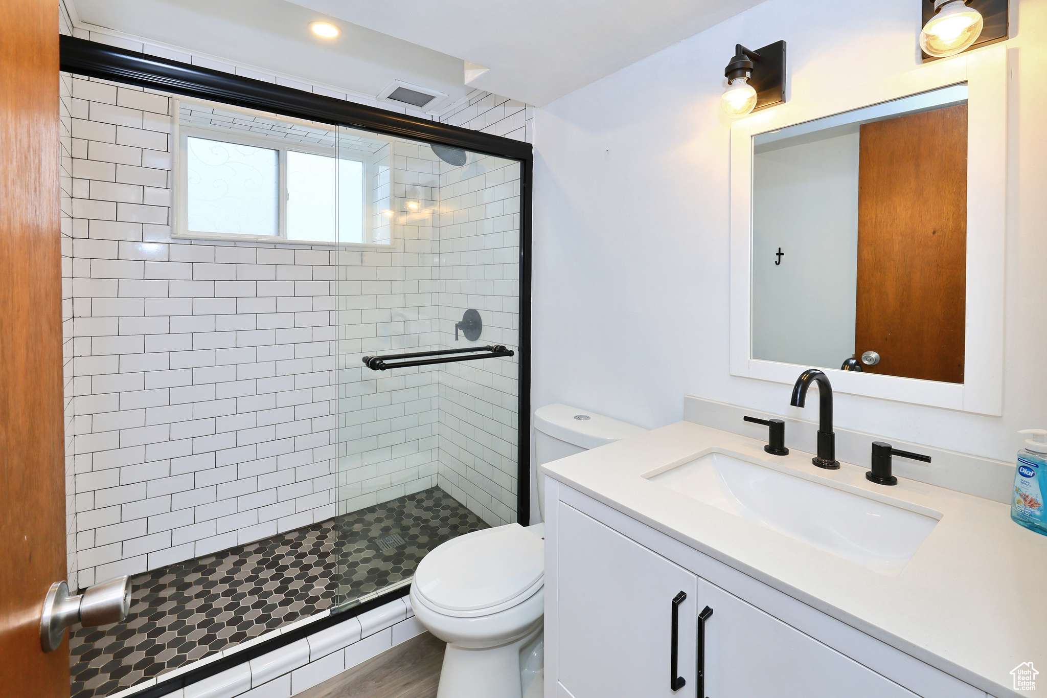 Bathroom featuring vanity, an enclosed shower, and toilet