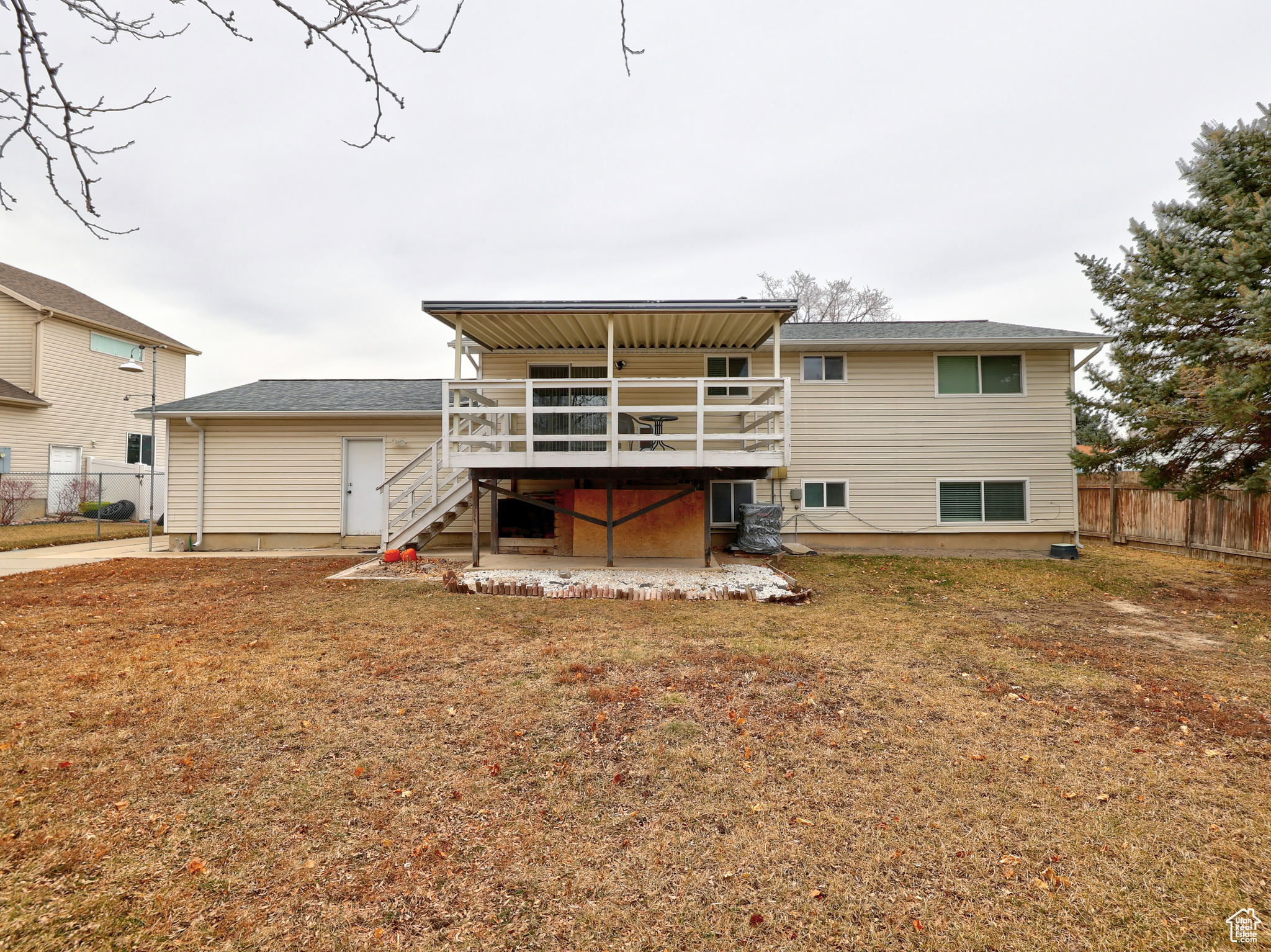 Rear view of house featuring a wooden deck and a lawn