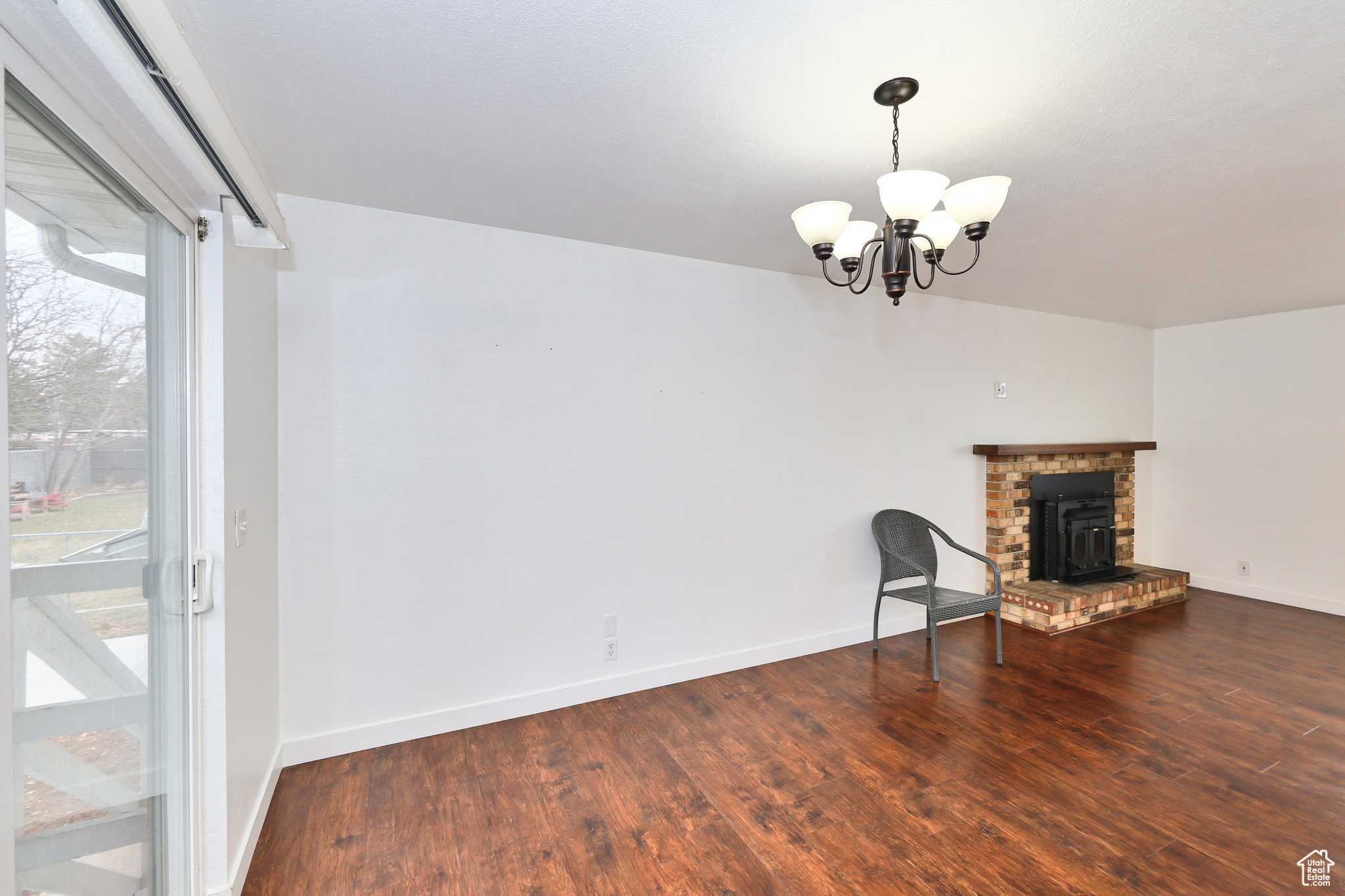 Unfurnished living room featuring dark hardwood / wood-style floors and a chandelier