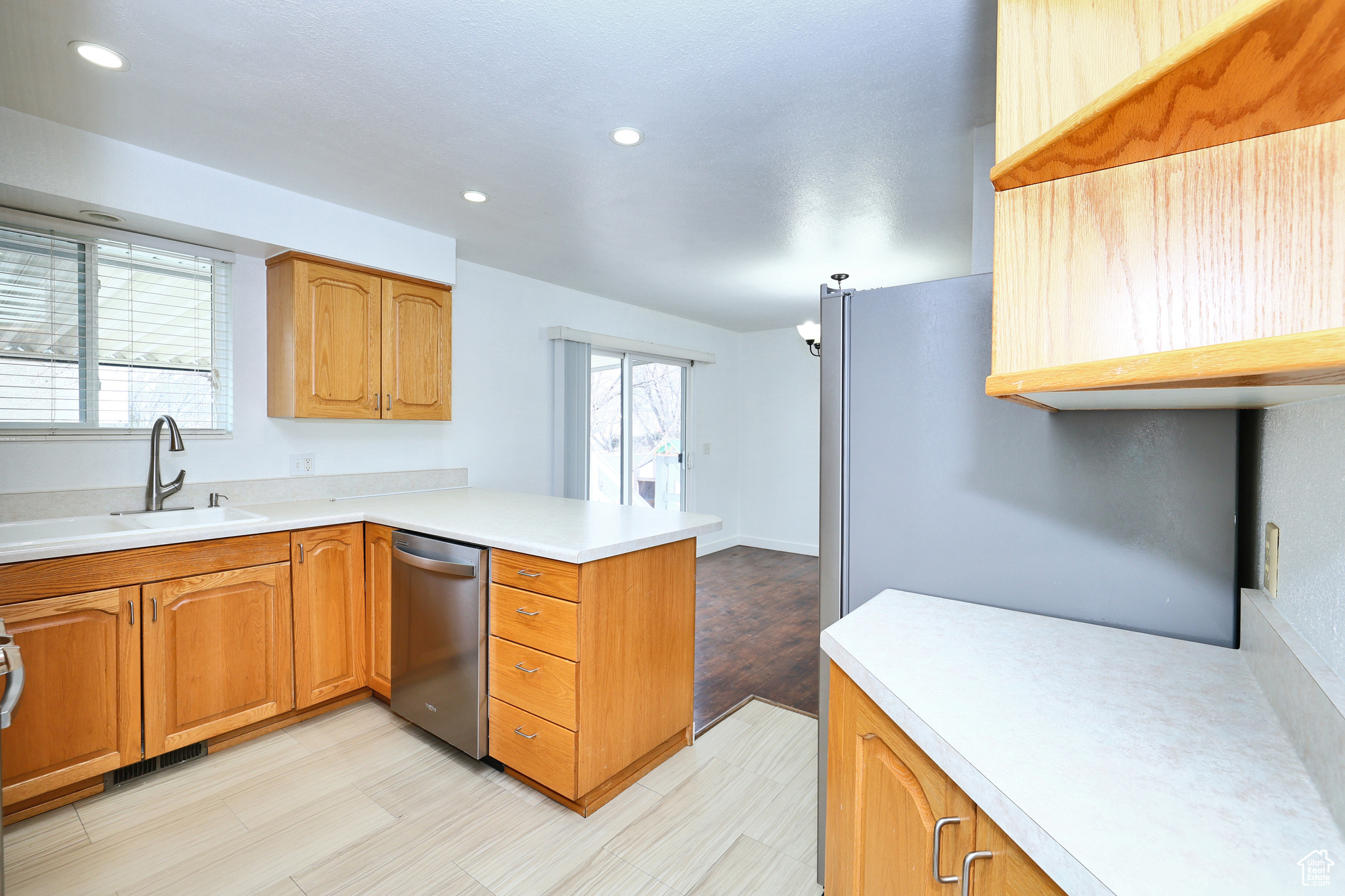 Kitchen featuring sink, a wealth of natural light, stainless steel dishwasher, and kitchen peninsula