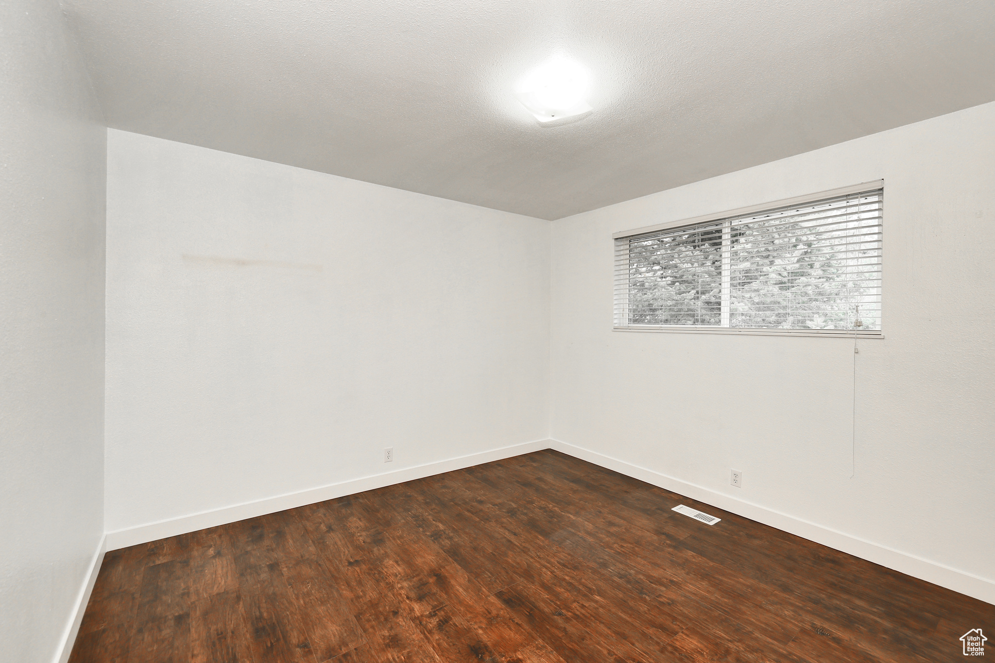 Empty room with dark hardwood / wood-style floors