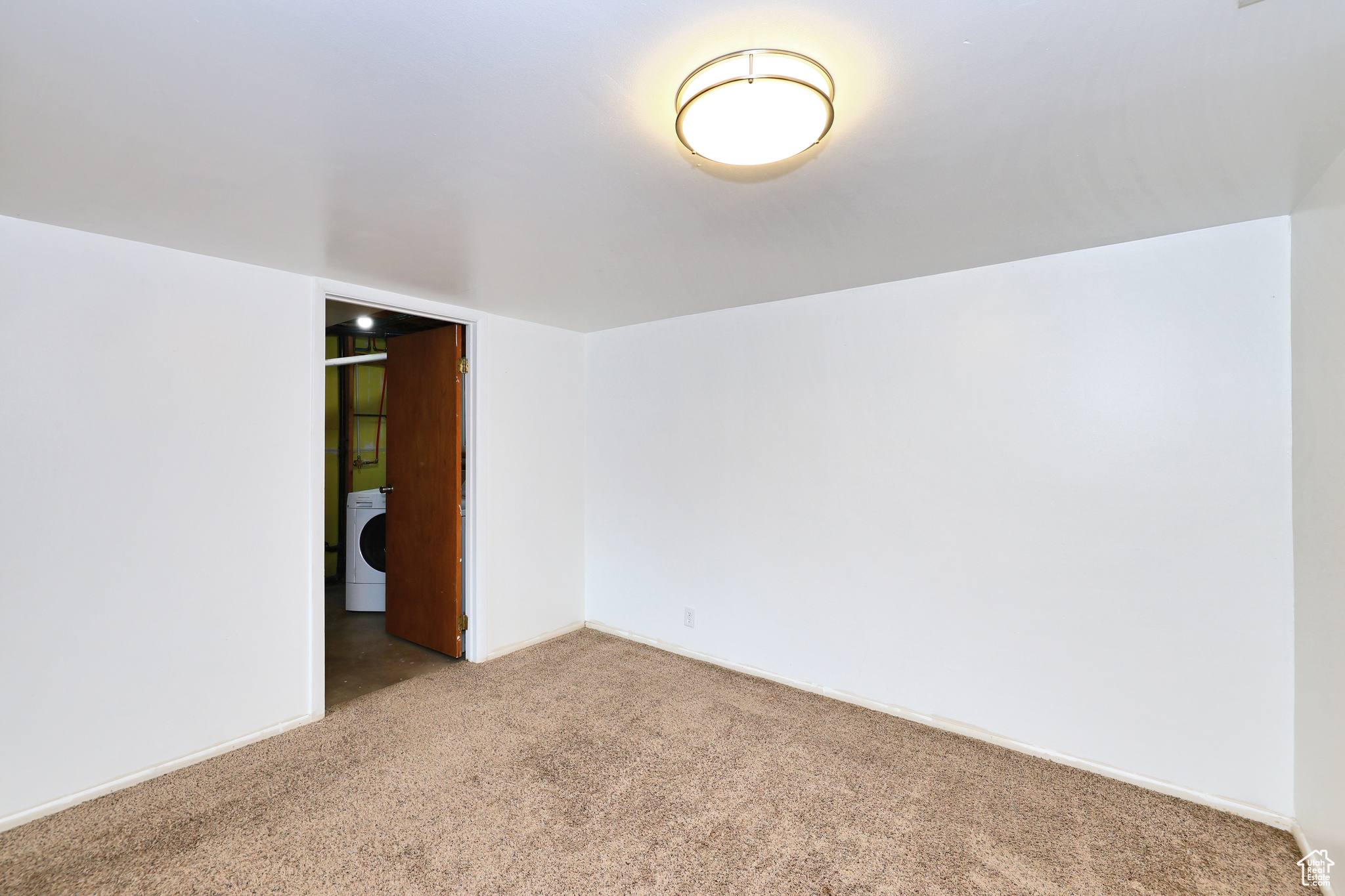 Spare room featuring washer / clothes dryer and carpet