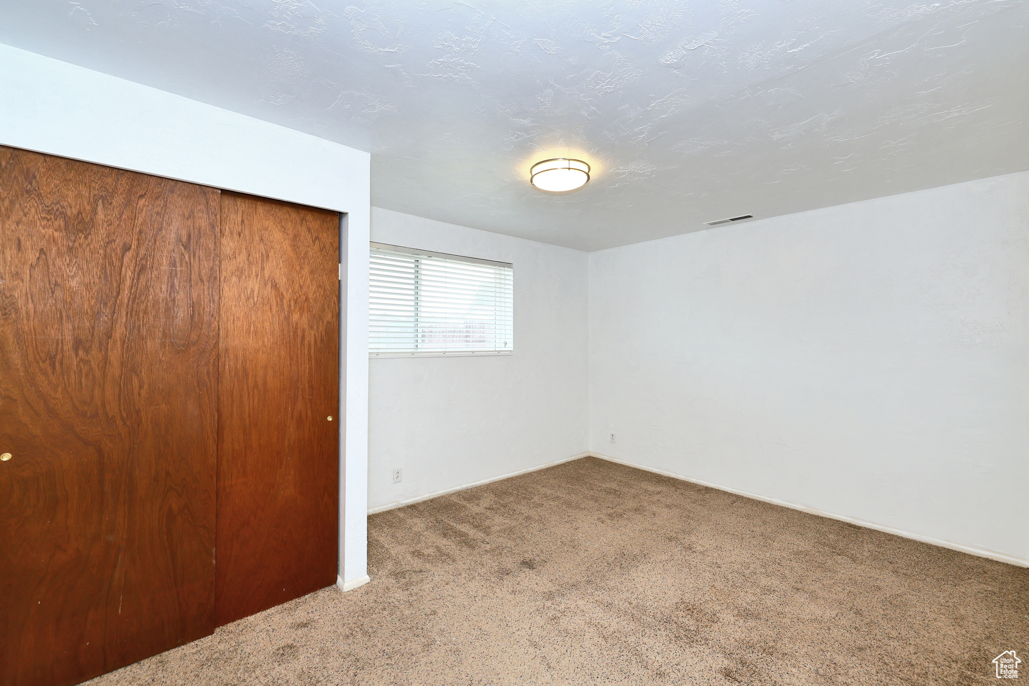 Unfurnished bedroom featuring carpet and a closet