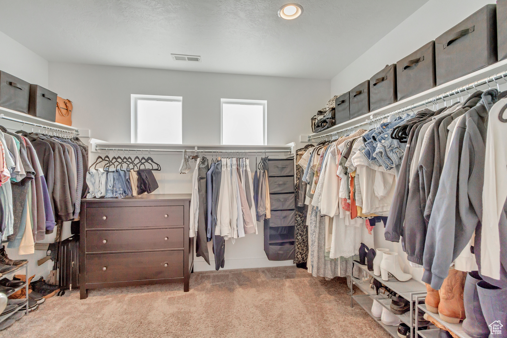 Walk in closet featuring light colored carpet