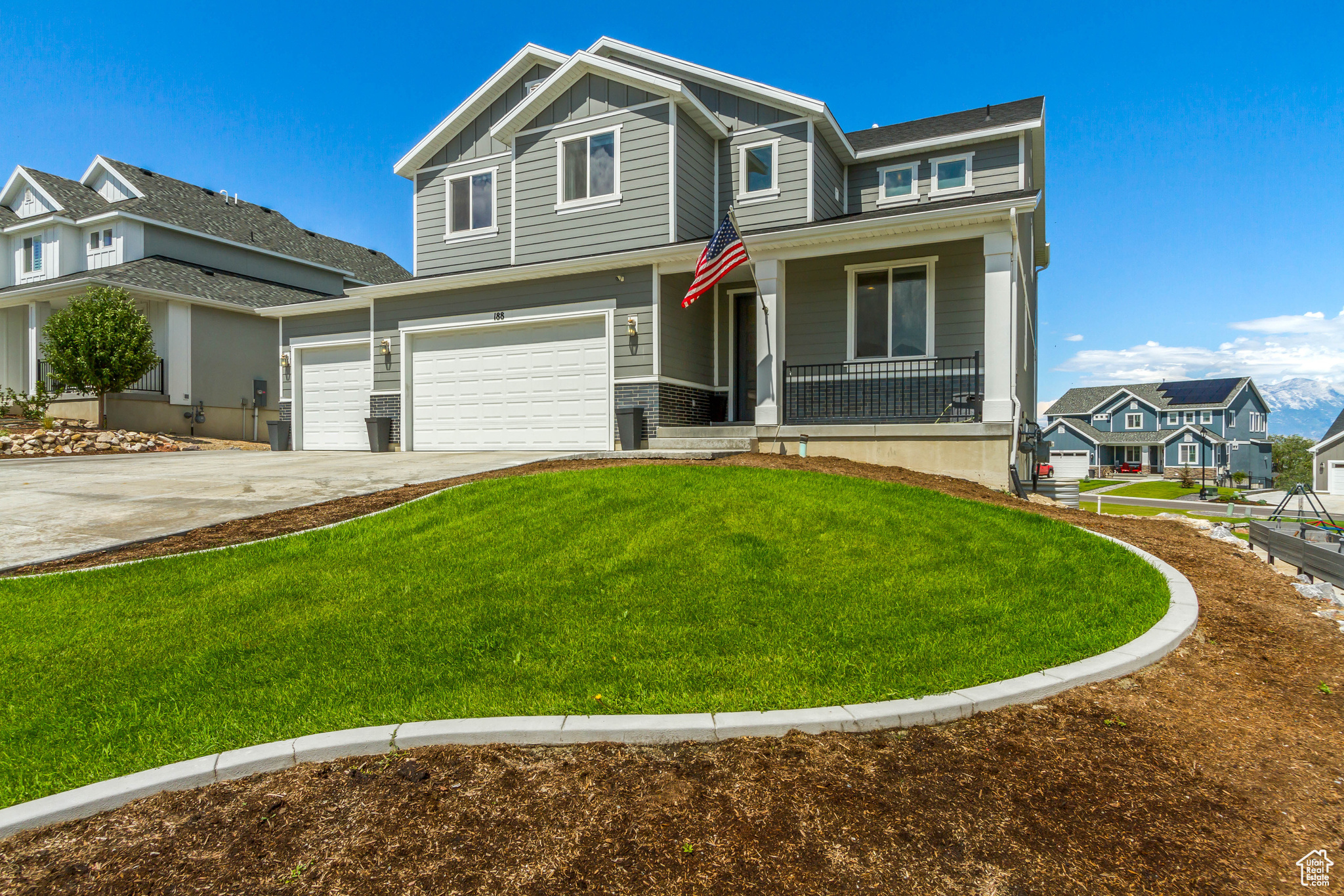 View of front of house with a garage, a front lawn, and a porch