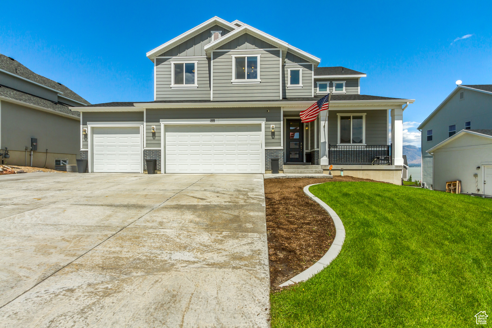 View of front of house with a porch, a garage, and a front lawn