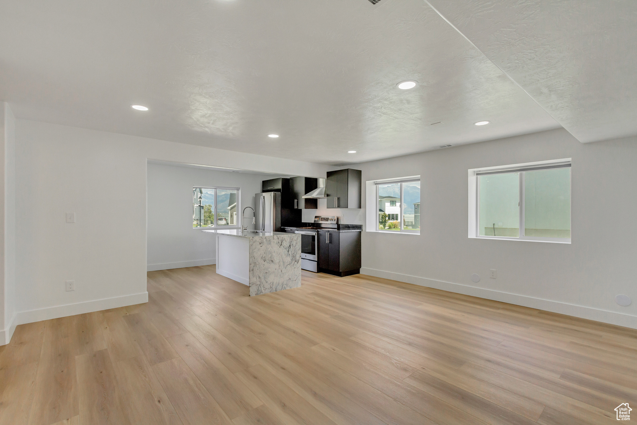 Unfurnished living room featuring sink and light hardwood / wood-style floors