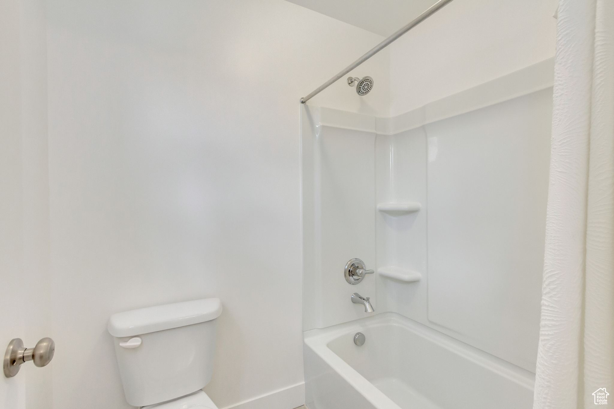 Bathroom featuring shower / bathtub combination with curtain and toilet