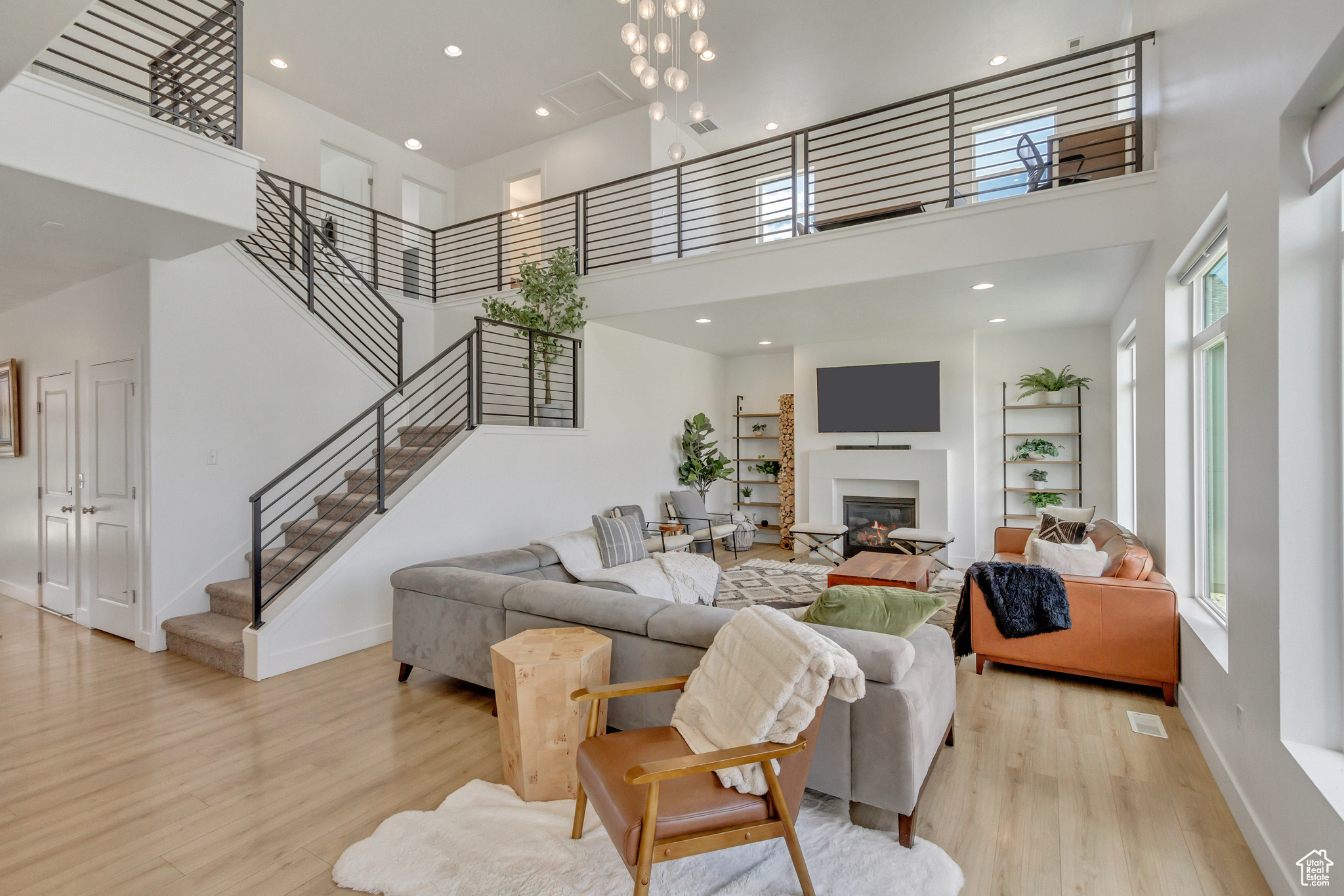 Living room with a towering ceiling and light hardwood / wood-style floors