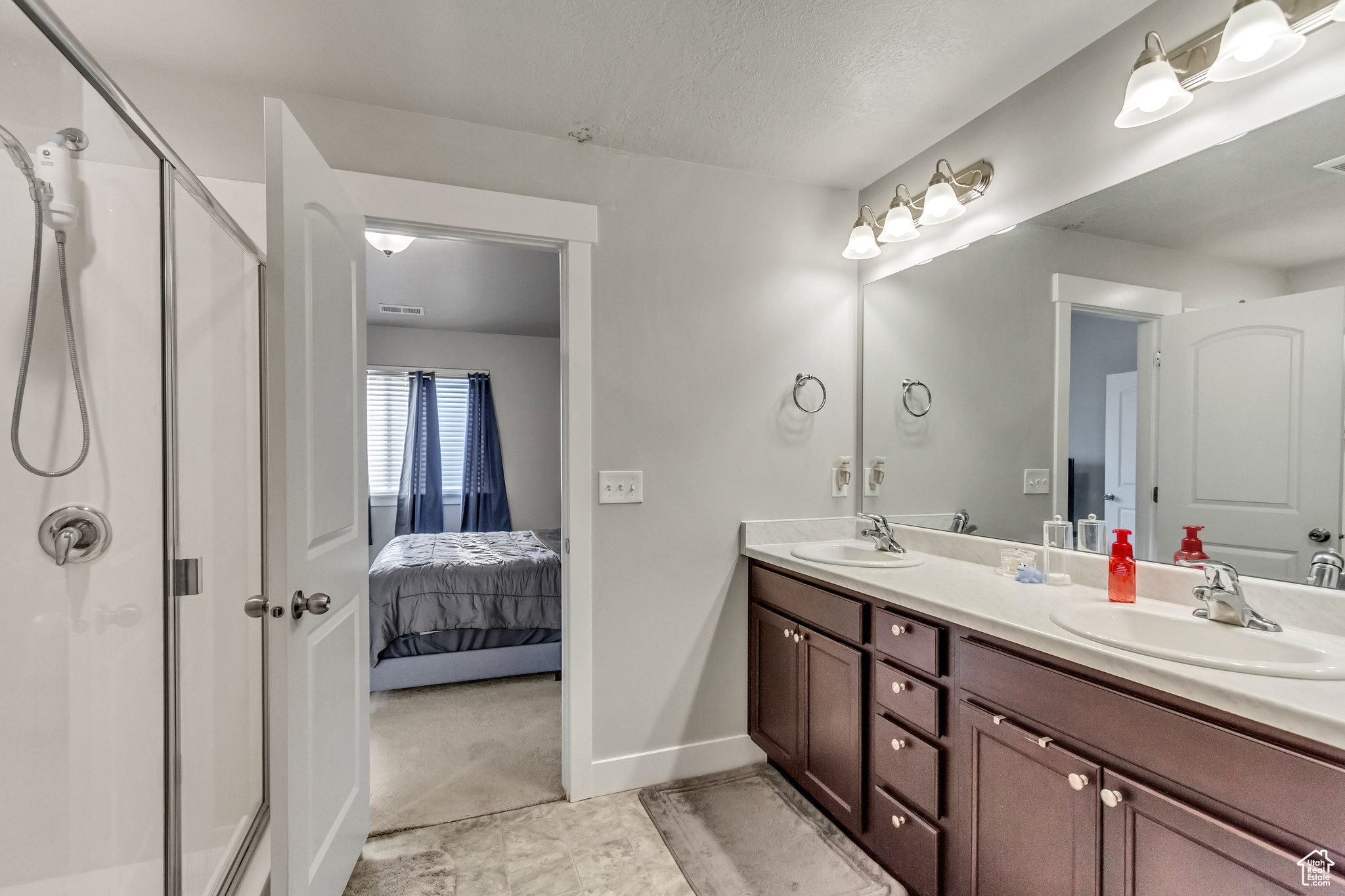 Bathroom with vanity, a textured ceiling, and walk in shower