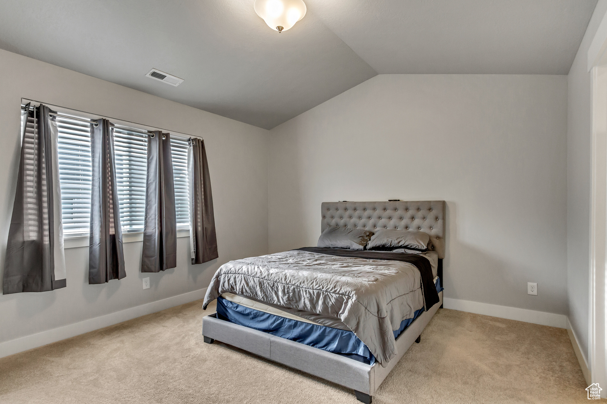 Carpeted bedroom with lofted ceiling