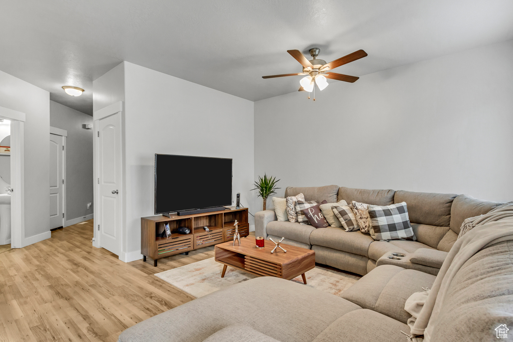 Living room with ceiling fan and light hardwood / wood-style floors