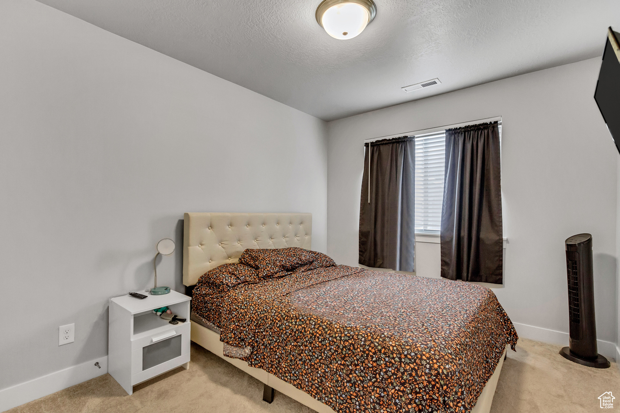 Bedroom featuring carpet floors and a textured ceiling