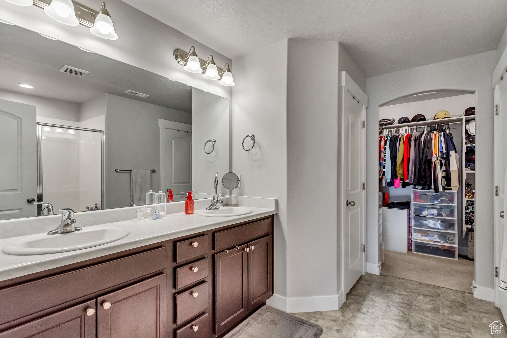 Bathroom featuring vanity and a shower with door