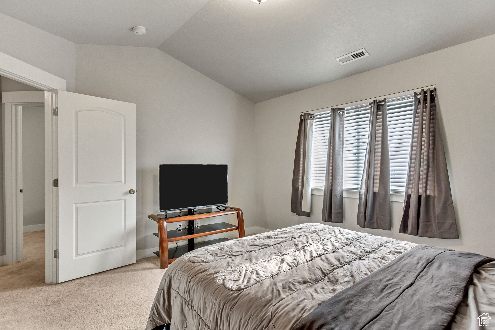 Bedroom with lofted ceiling and carpet floors