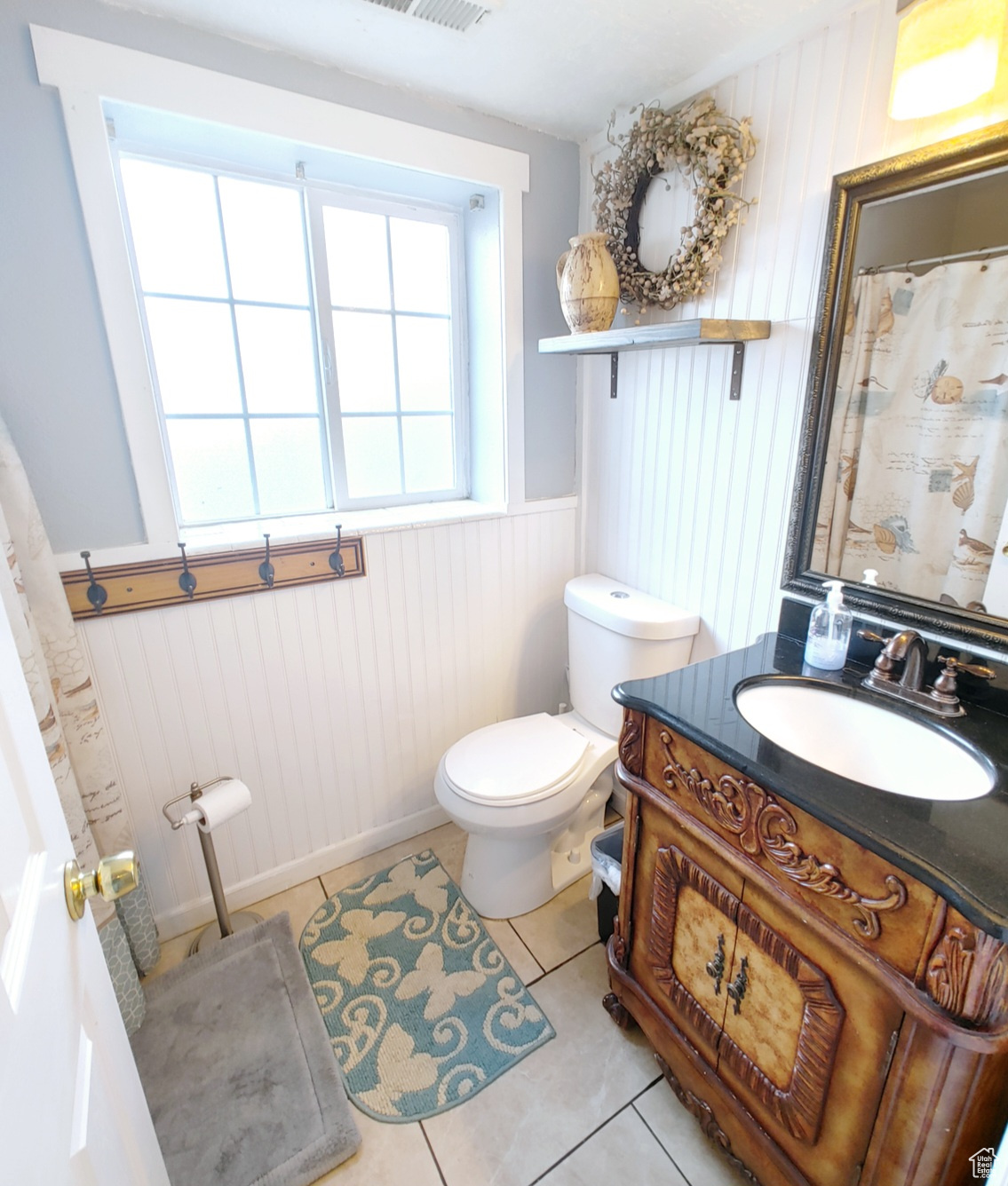 Bathroom featuring vanity, tile patterned floors, and toilet