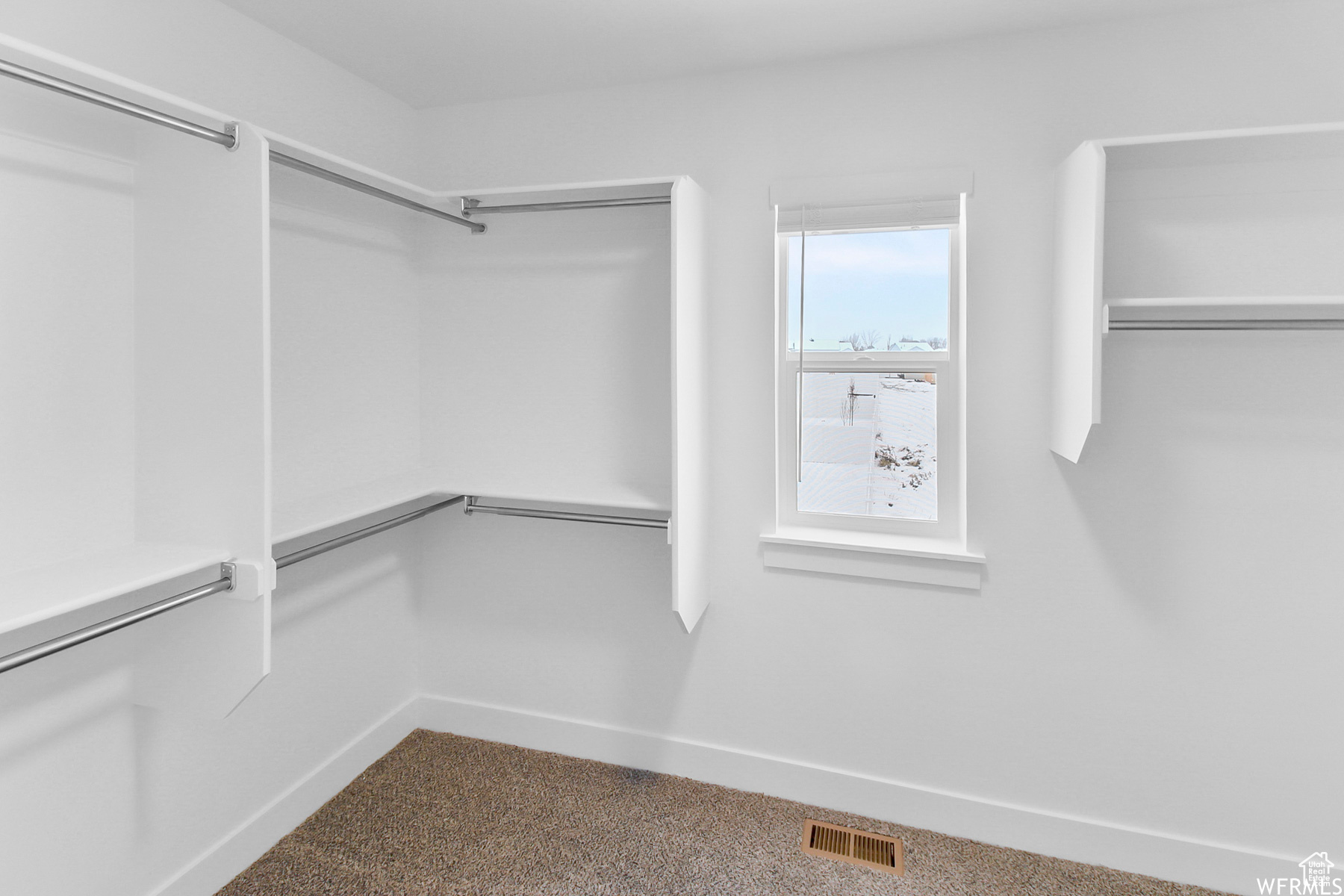 Walk in closet featuring built-in shelving and window