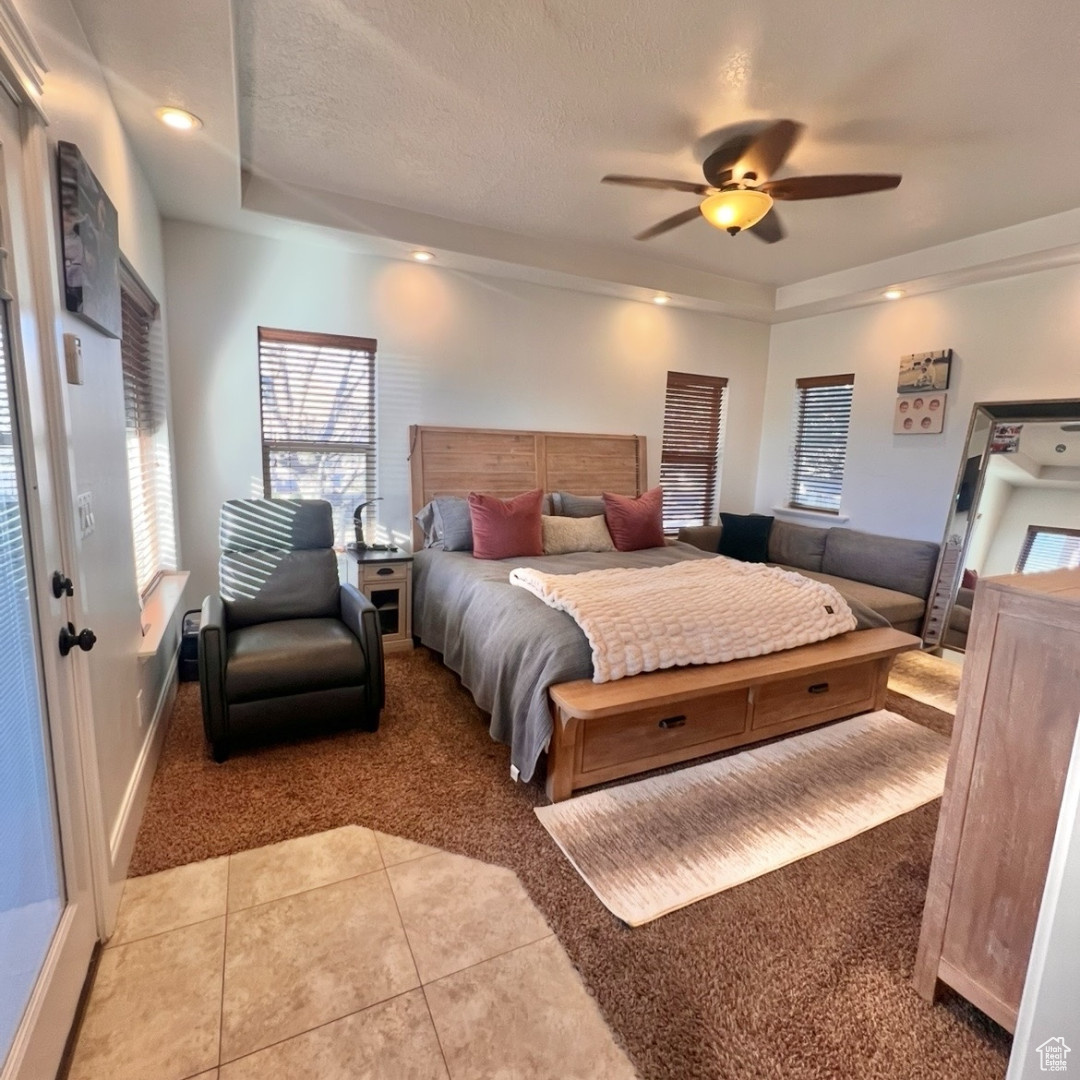 Tiled bedroom with a textured ceiling and ceiling fan