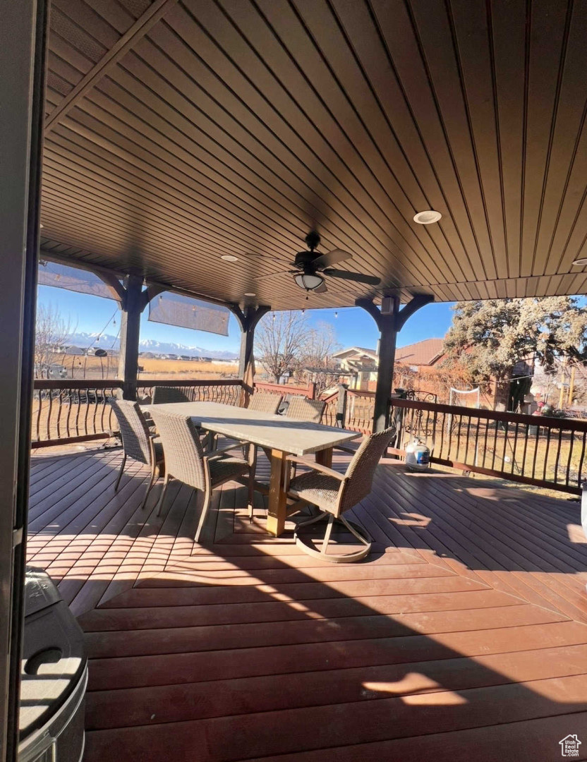 Wooden terrace featuring a mountain view and ceiling fan